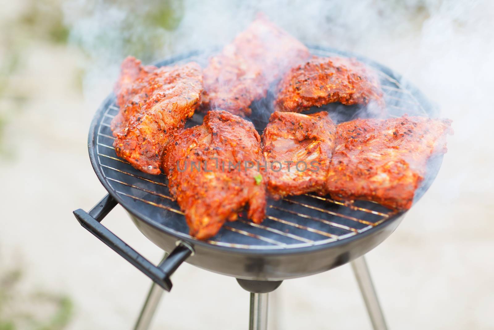 food and summer holidays - close up of meat on grill outdoors