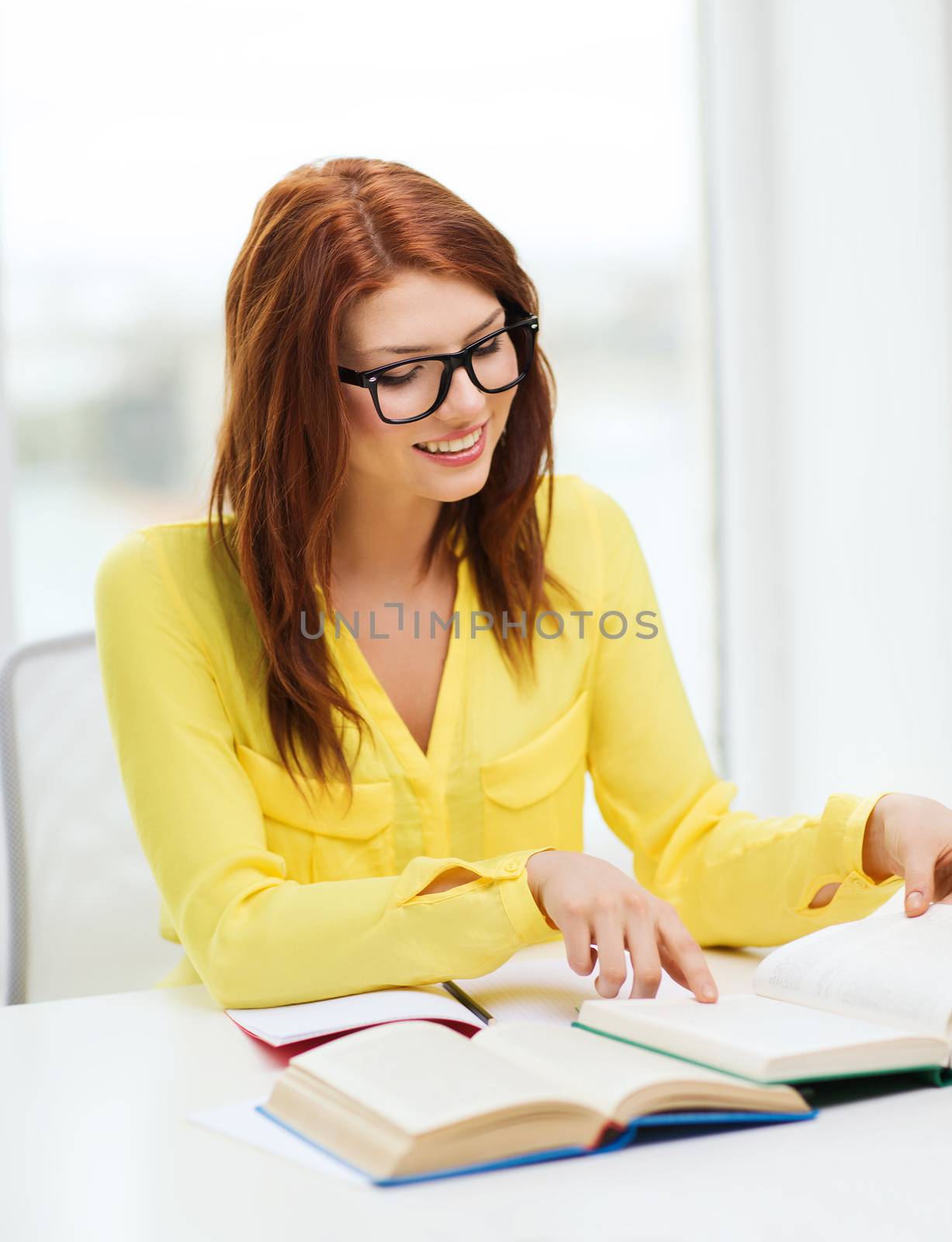 smiling student girl reading books in college by dolgachov