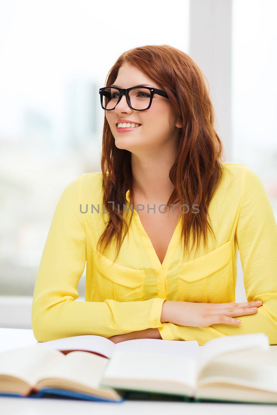 education concept - smiling student girl in eyeglasses listening lecture in college