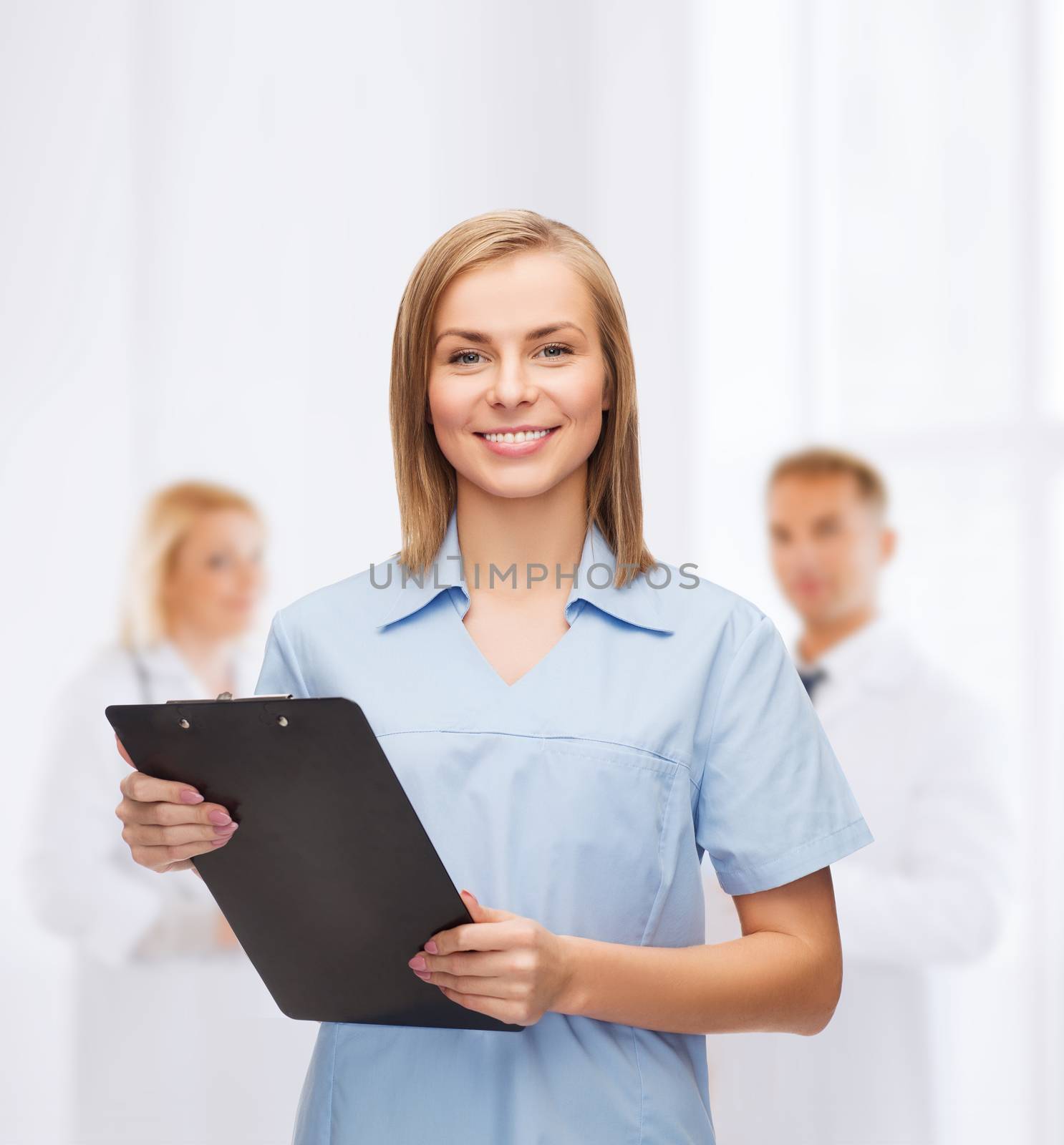 smiling female doctor or nurse with clipboard by dolgachov