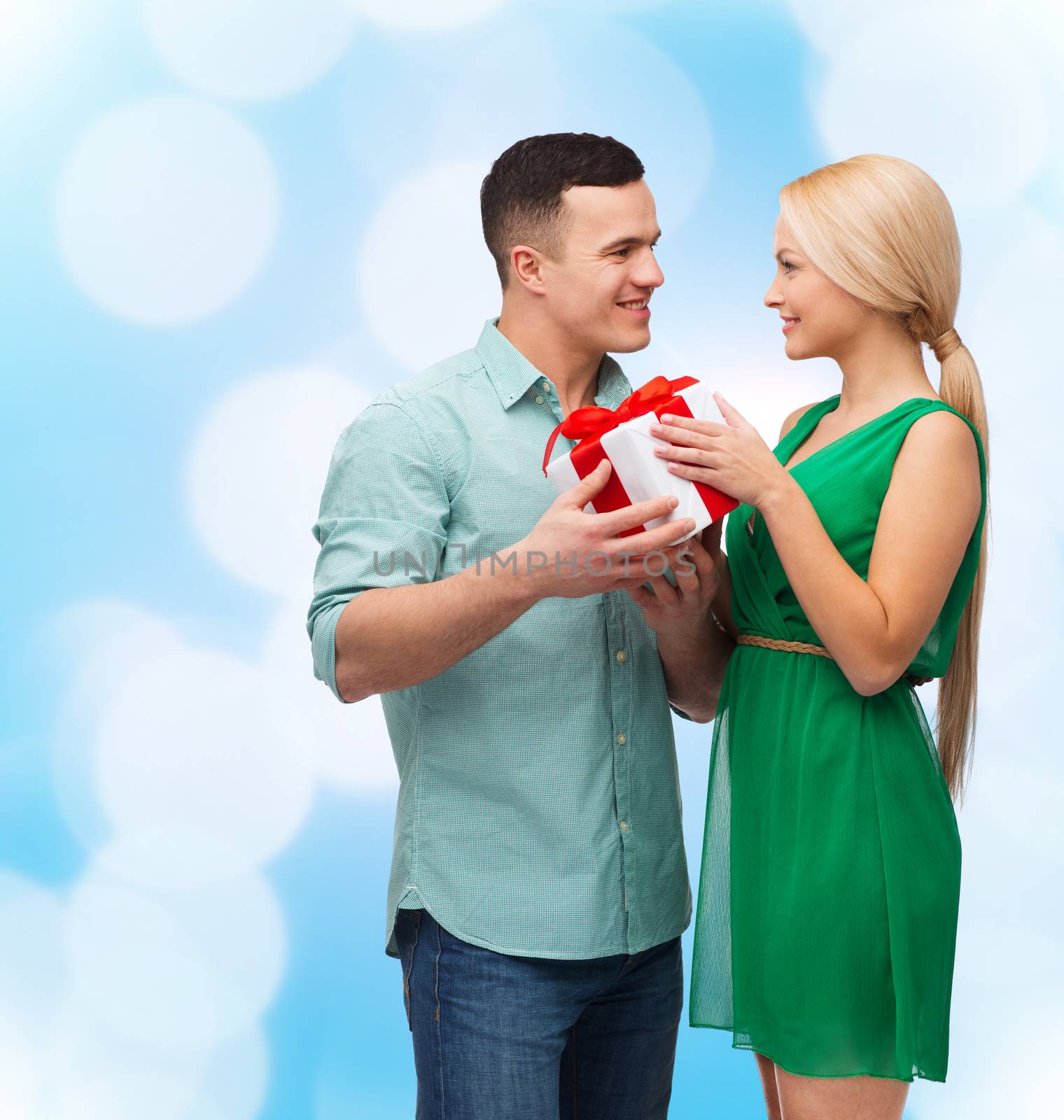 happiness, holidays, celebration and couple concept - smiling couple with gift box