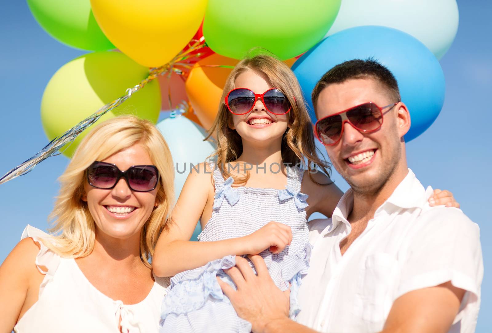 happy family with colorful balloons outdoors by dolgachov