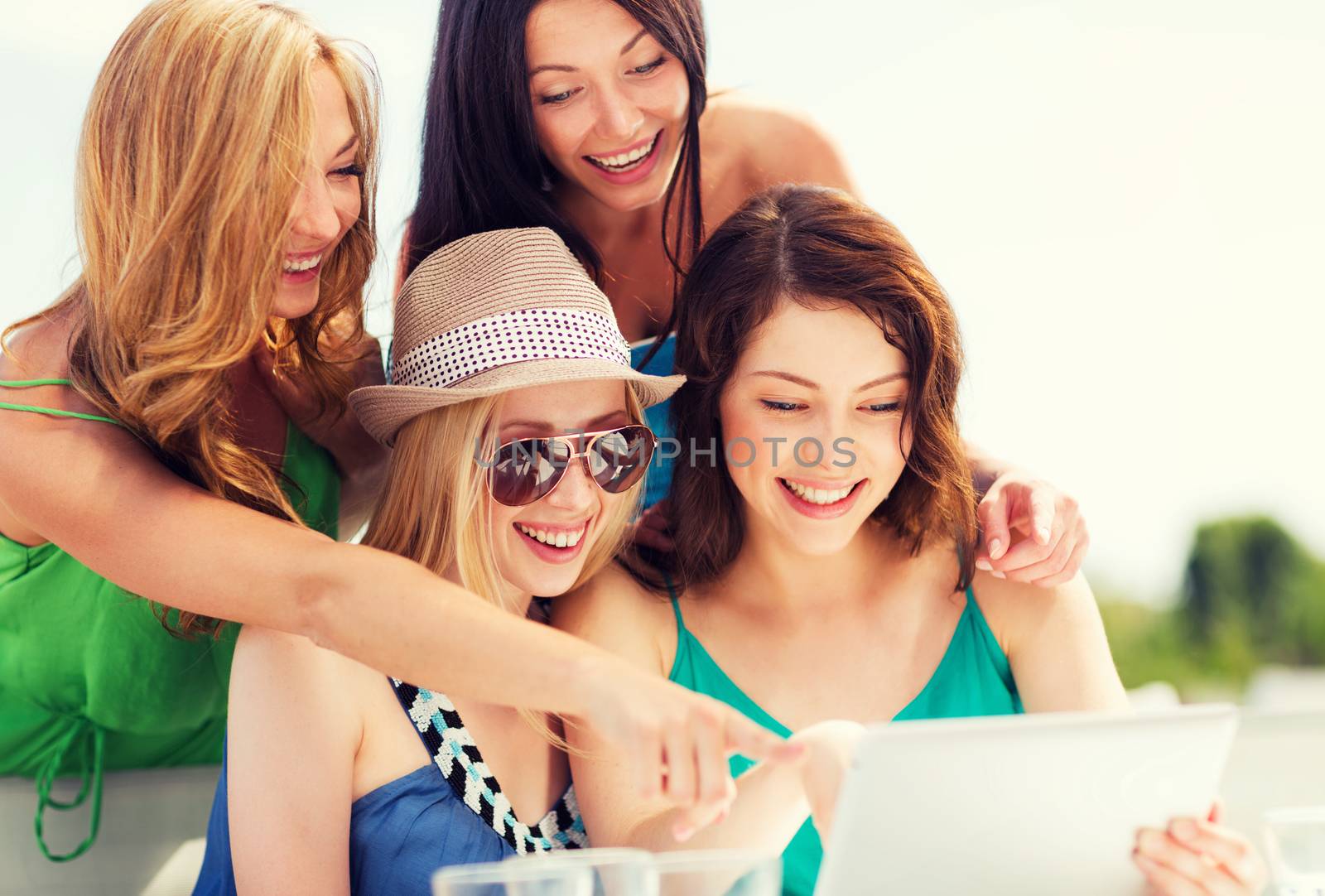 summer holidays, vacation, internet and technology - girls looking at tablet pc in cafe