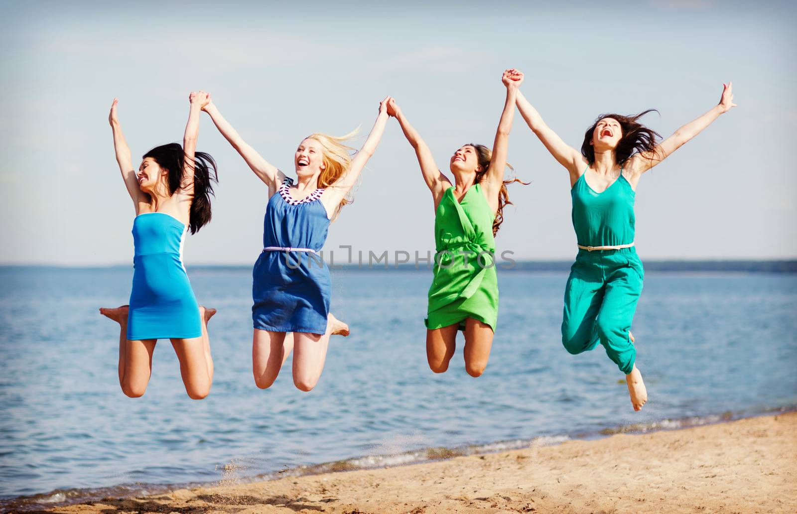 girls jumping on the beach by dolgachov