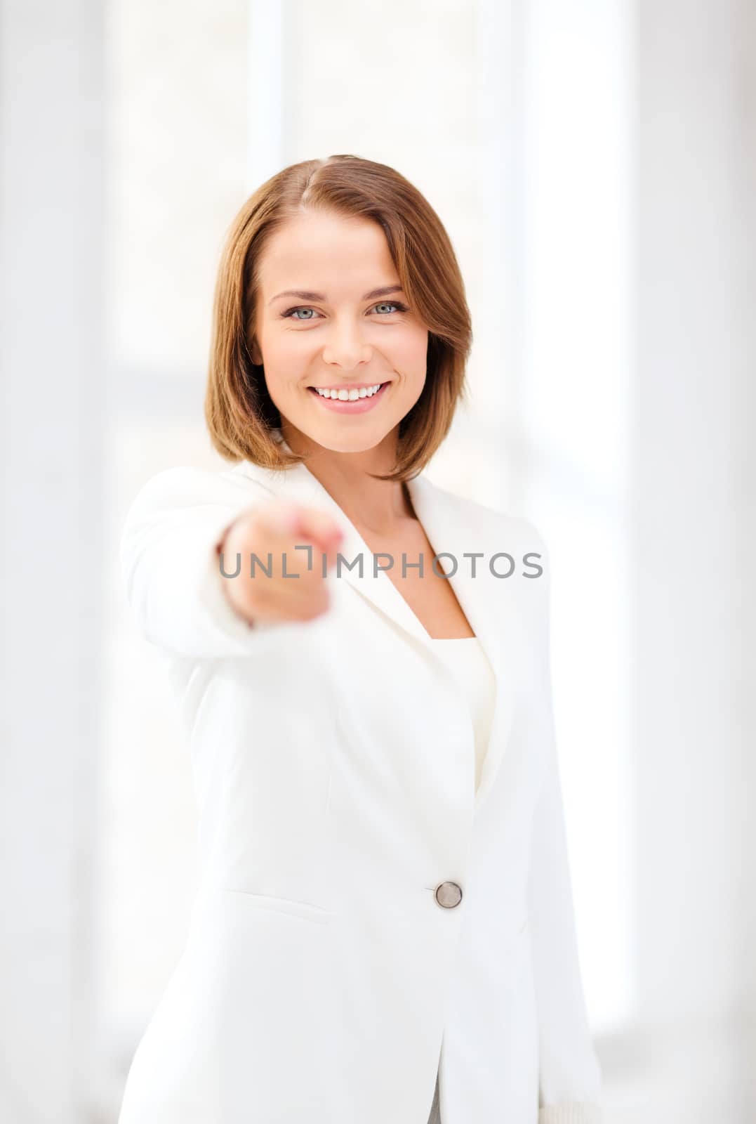 smiling businesswoman pointing finger at you by dolgachov