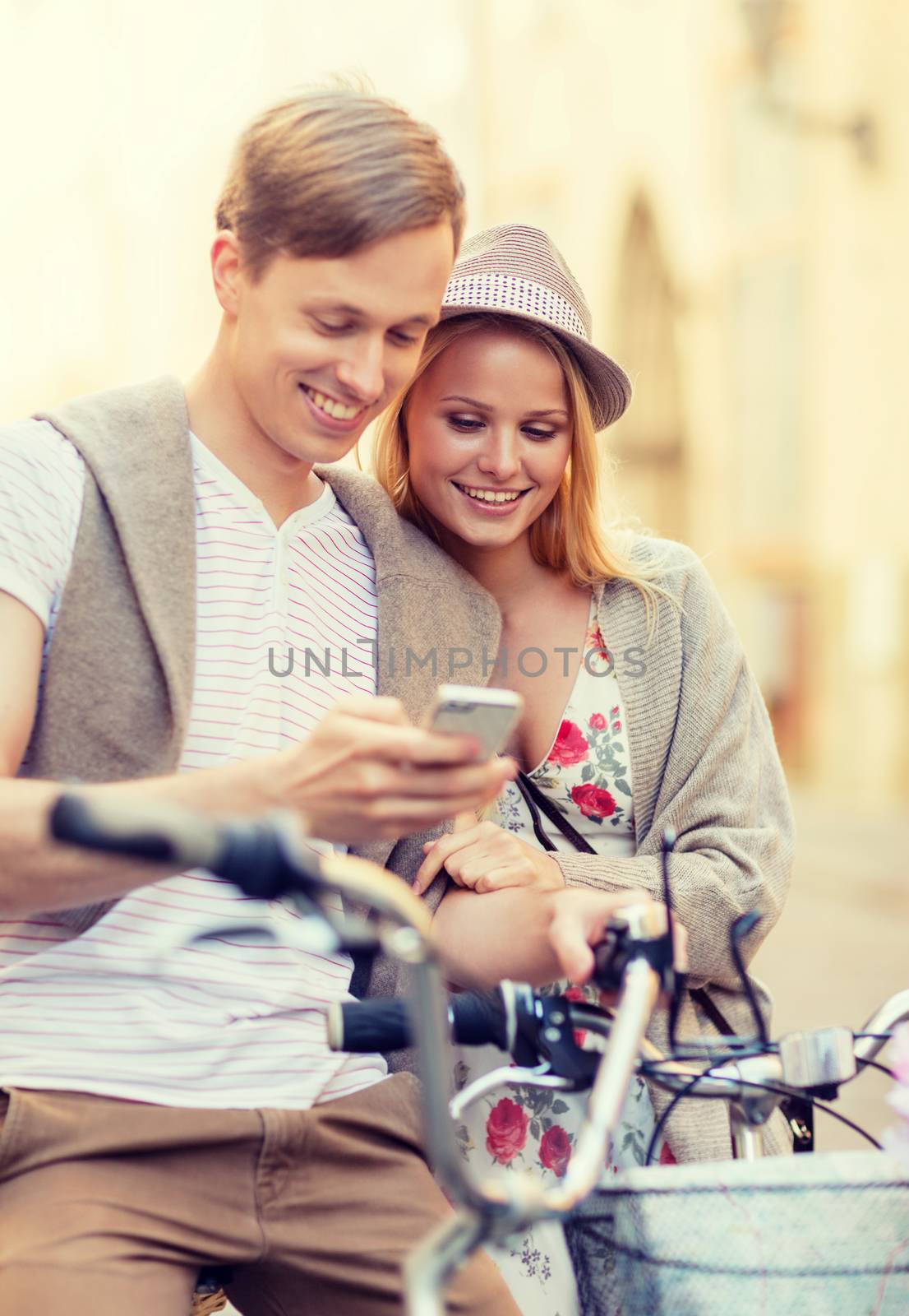 summer holidays, apps and dating concept - couple with bicycles and smartphone in the city