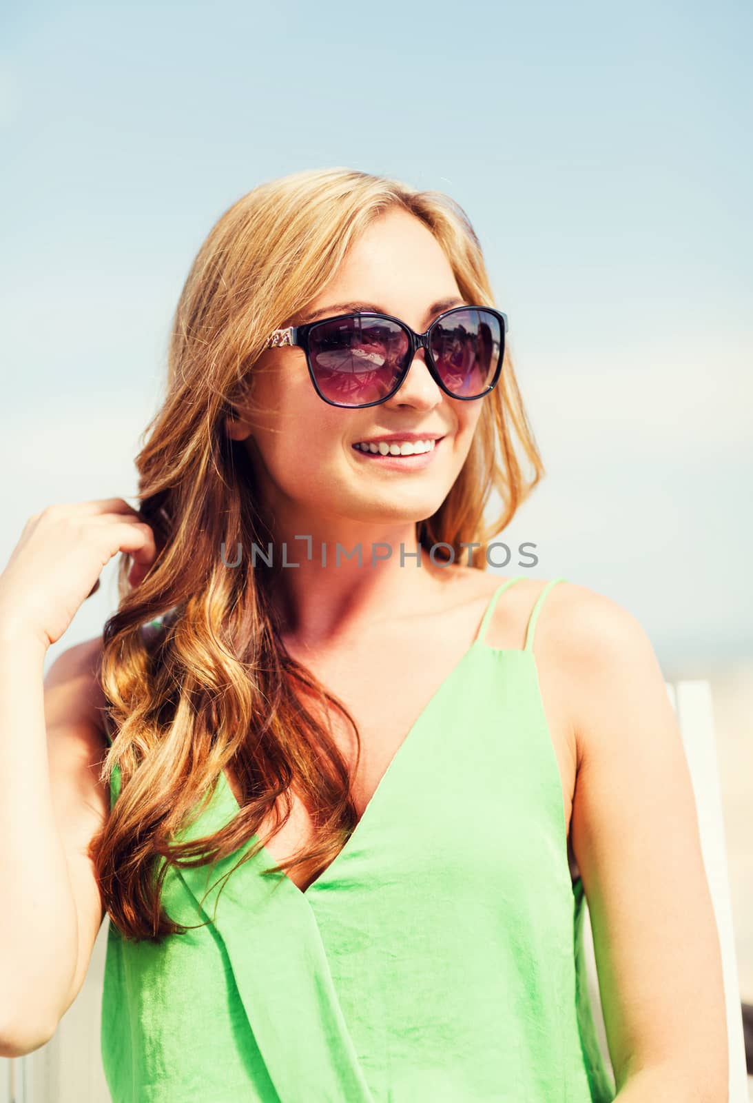 summer holidays and vacation - girl in shades in cafe on the beach