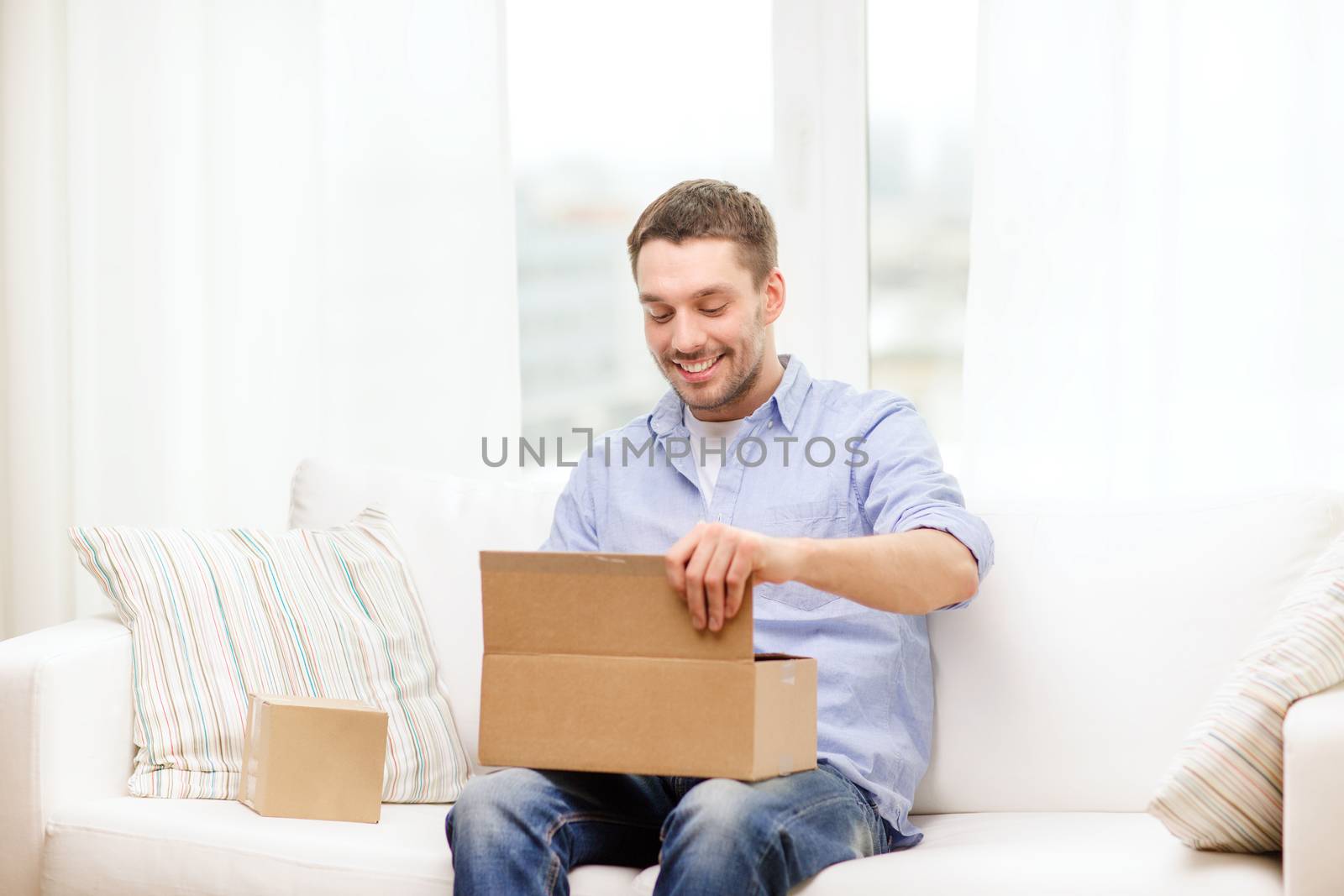 man with cardboard boxes at home by dolgachov