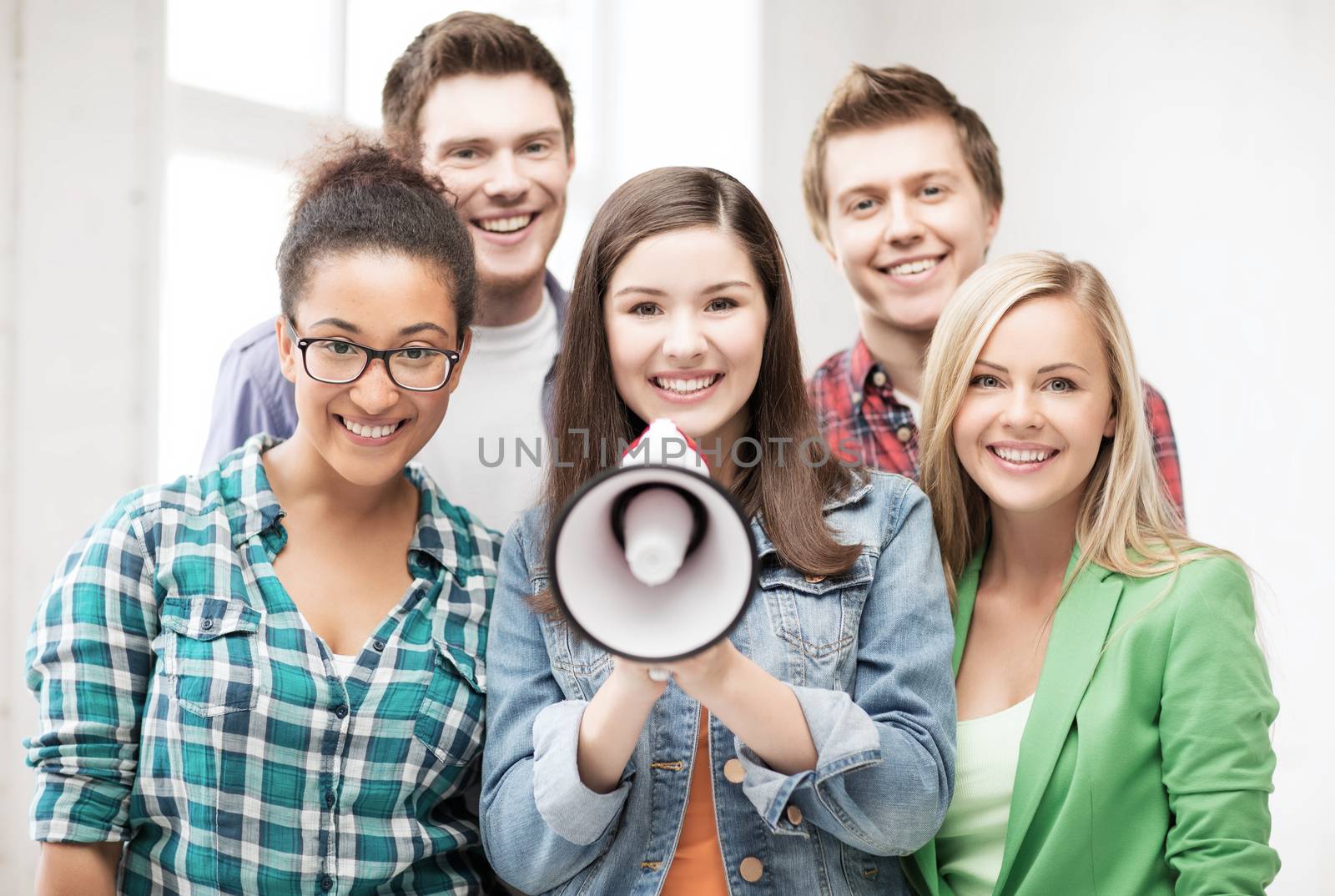education concept - group of students with megaphone at school