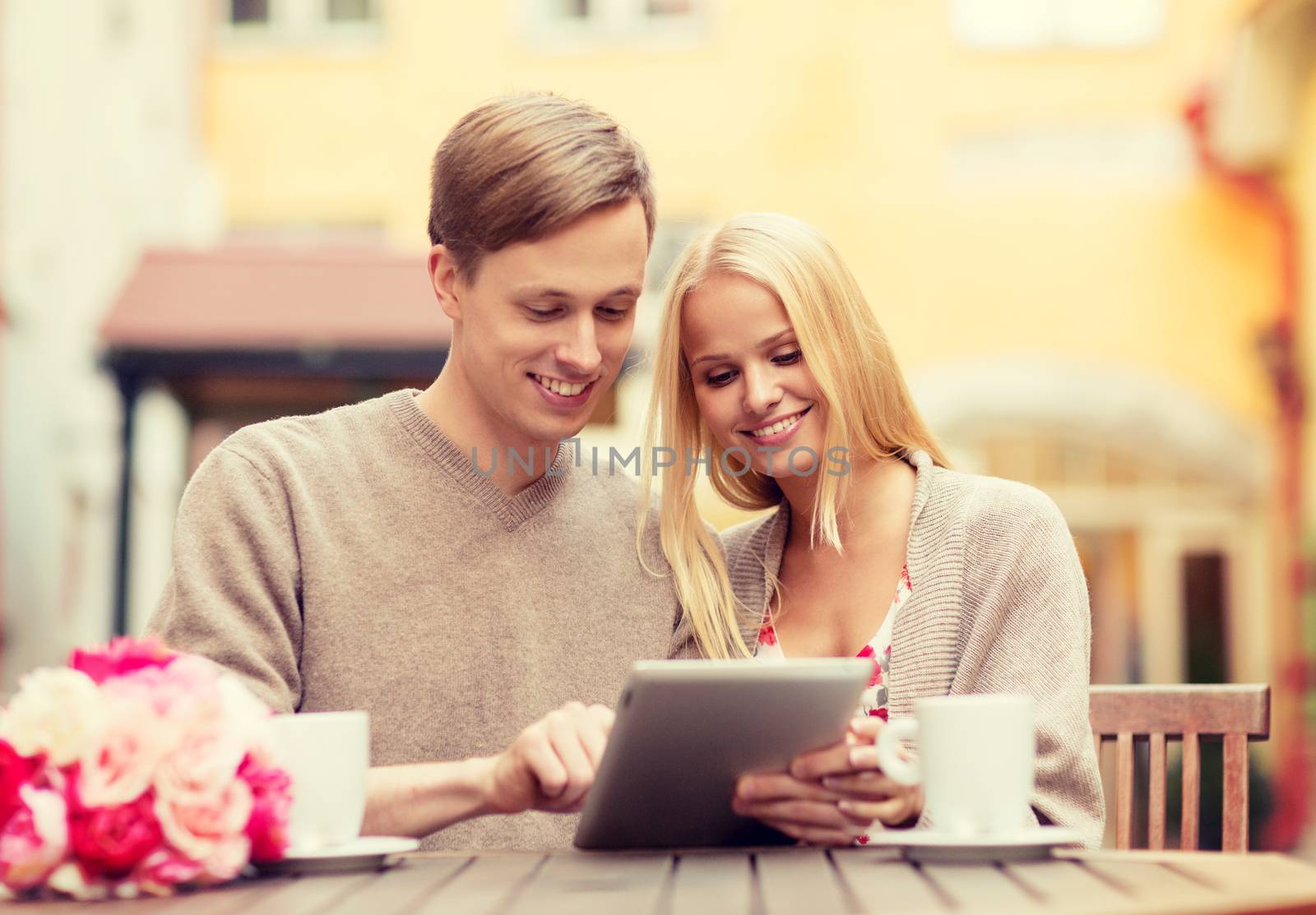 couple with tablet pc in cafe by dolgachov