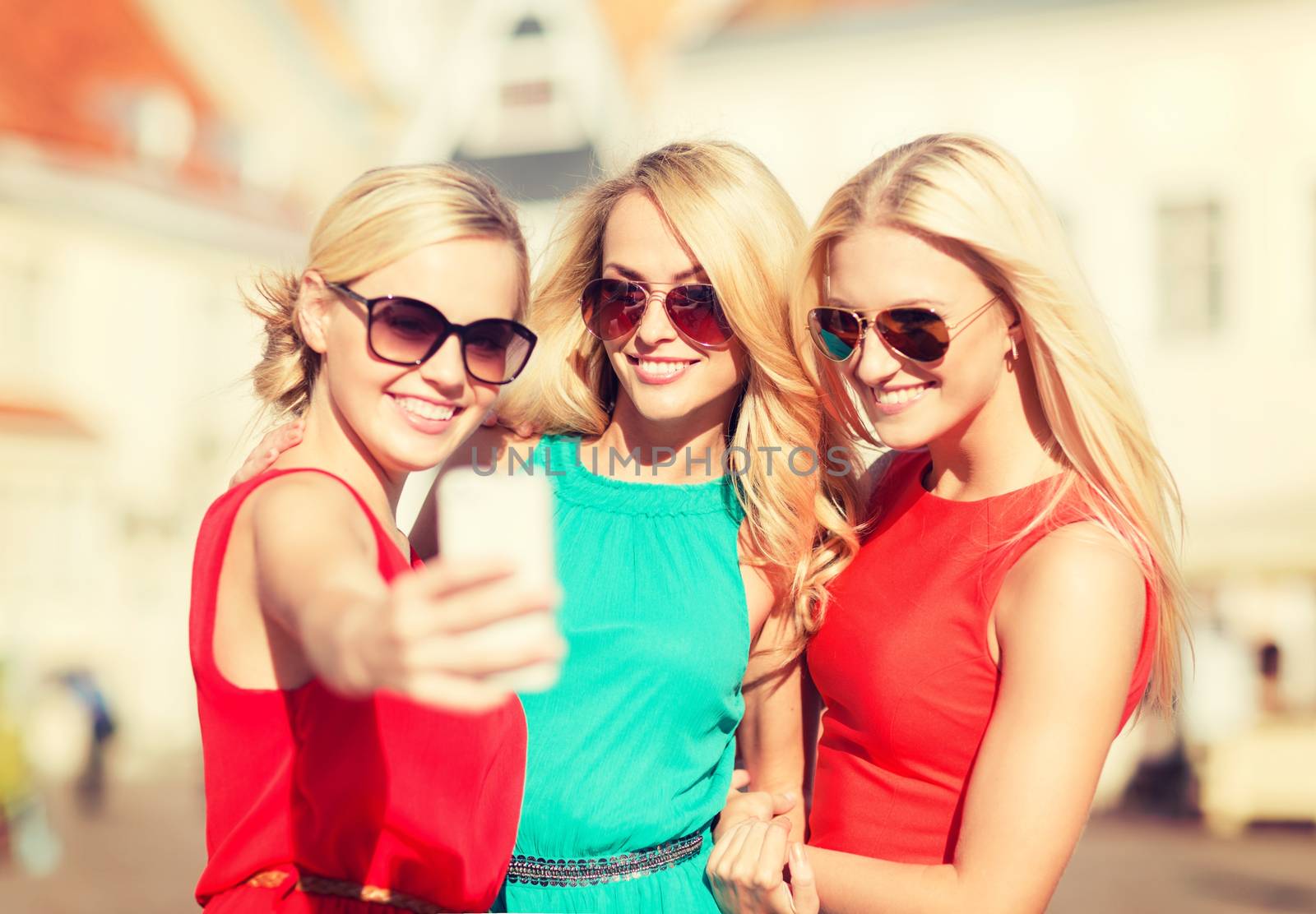 holidays and tourism, modern technology concept - beautiful girls taking picture in the city