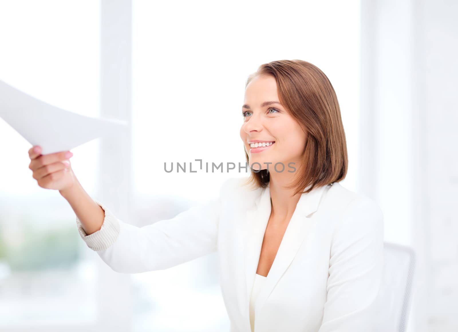 business and education concept - smiling businesswoman giving papers in office