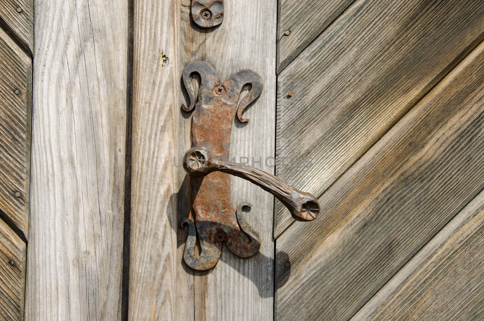 ancient rusty manor door handle on old wooden door