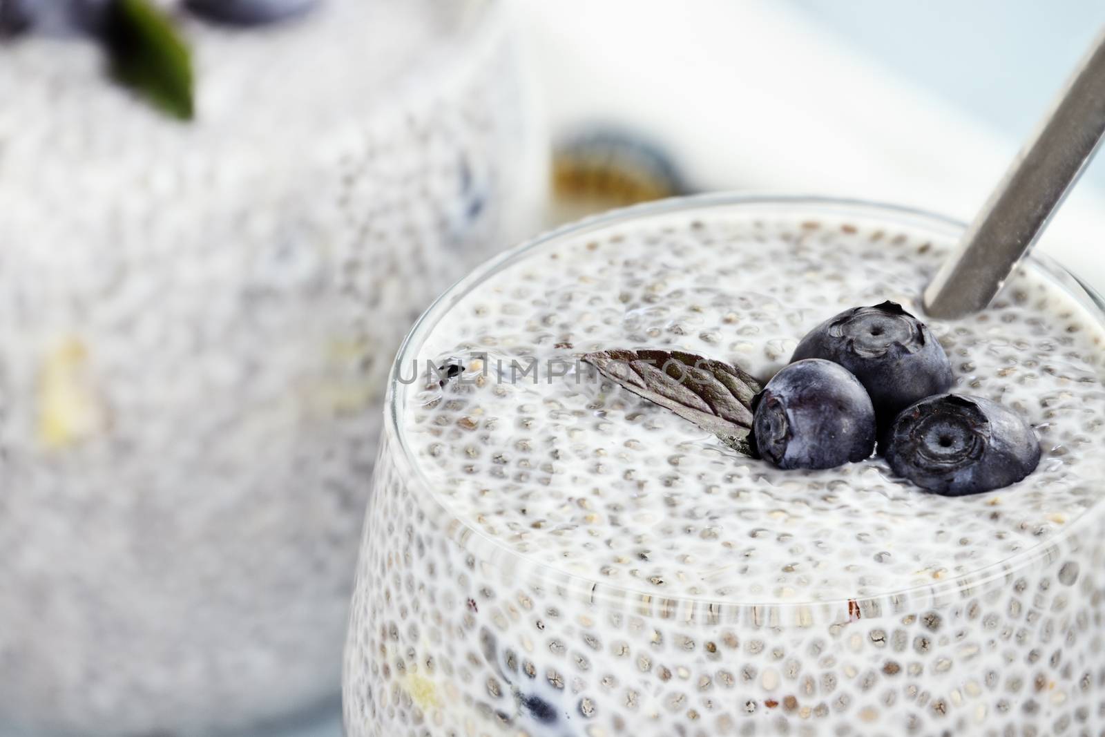 Chia seed pudding made with mangos and blueberries with extreme shallow depth of field.