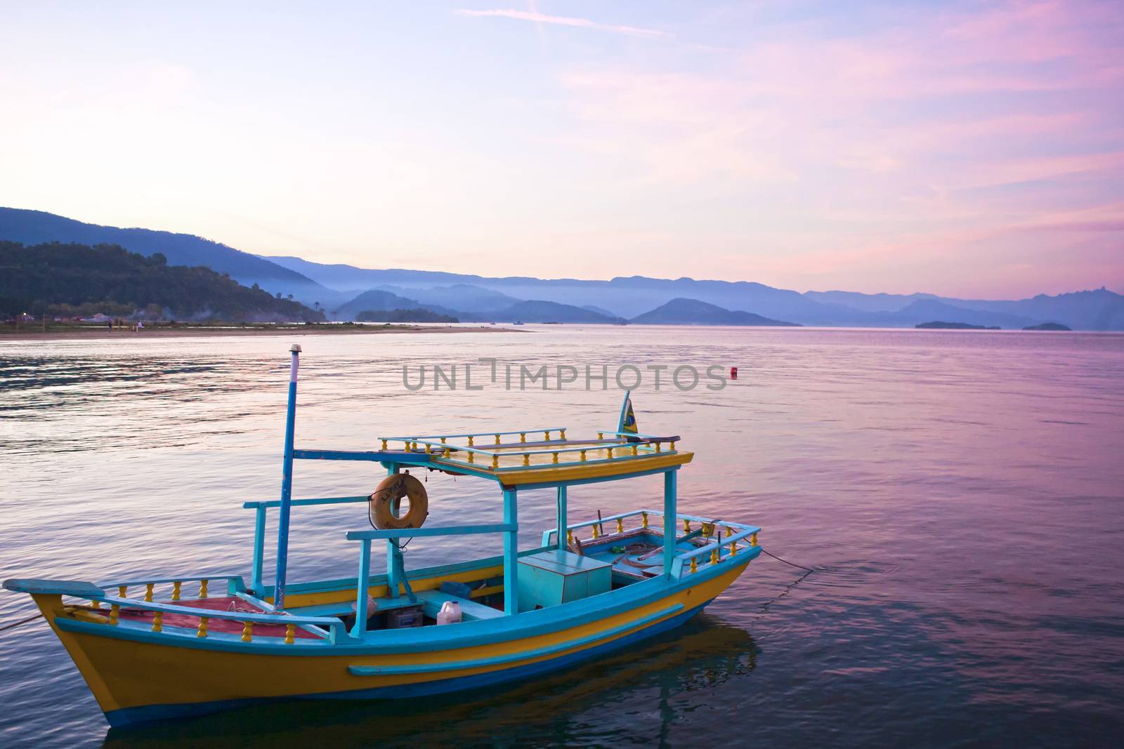 colorful boat at sunset in the bay of beautiful portuguese colonial typical town of parati in rio de janeiro state brazil