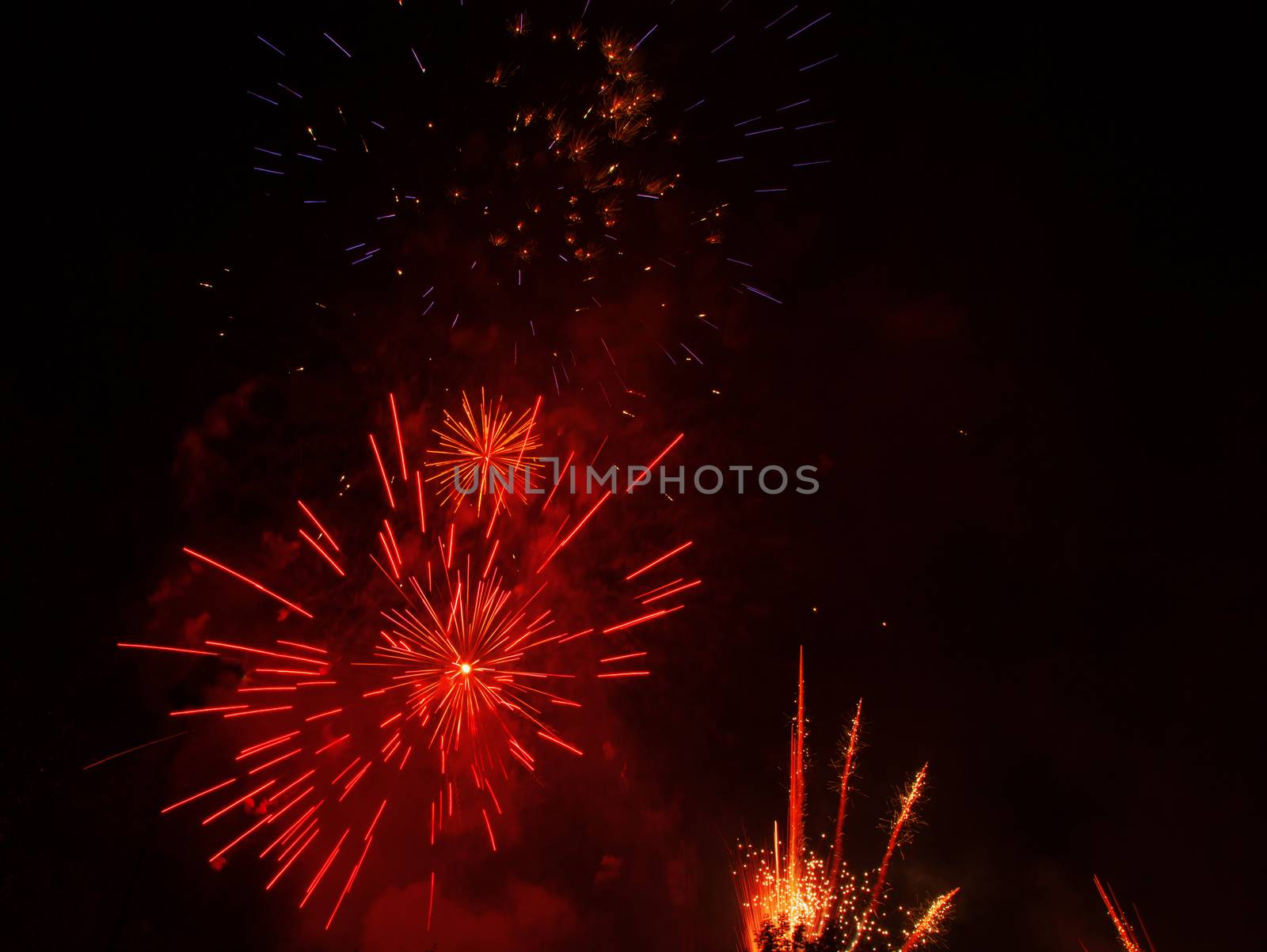 Red fireworks exploding in the black sky