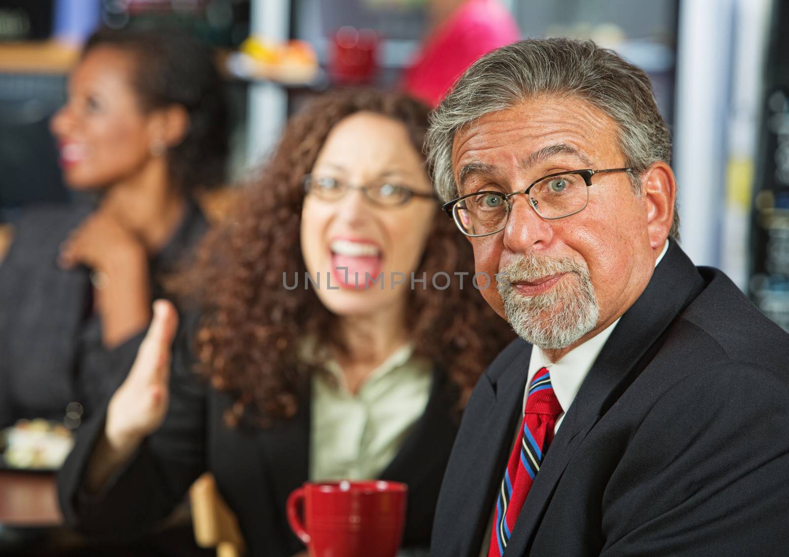 Frustrated businessman arguing with woman in cafeteria