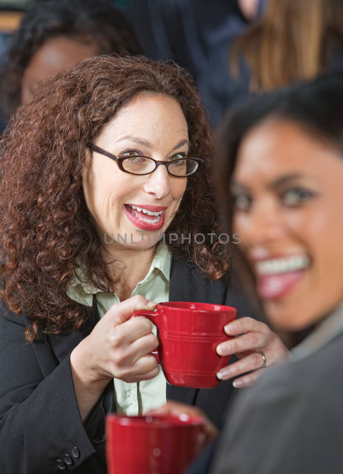 Two pretty business women laughing together in cafe