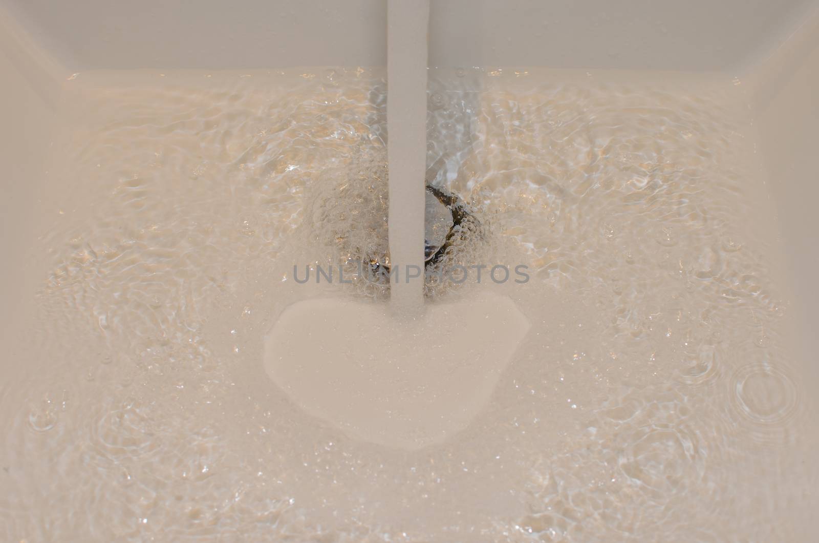 Water flowing down the hole in a bathroom sink