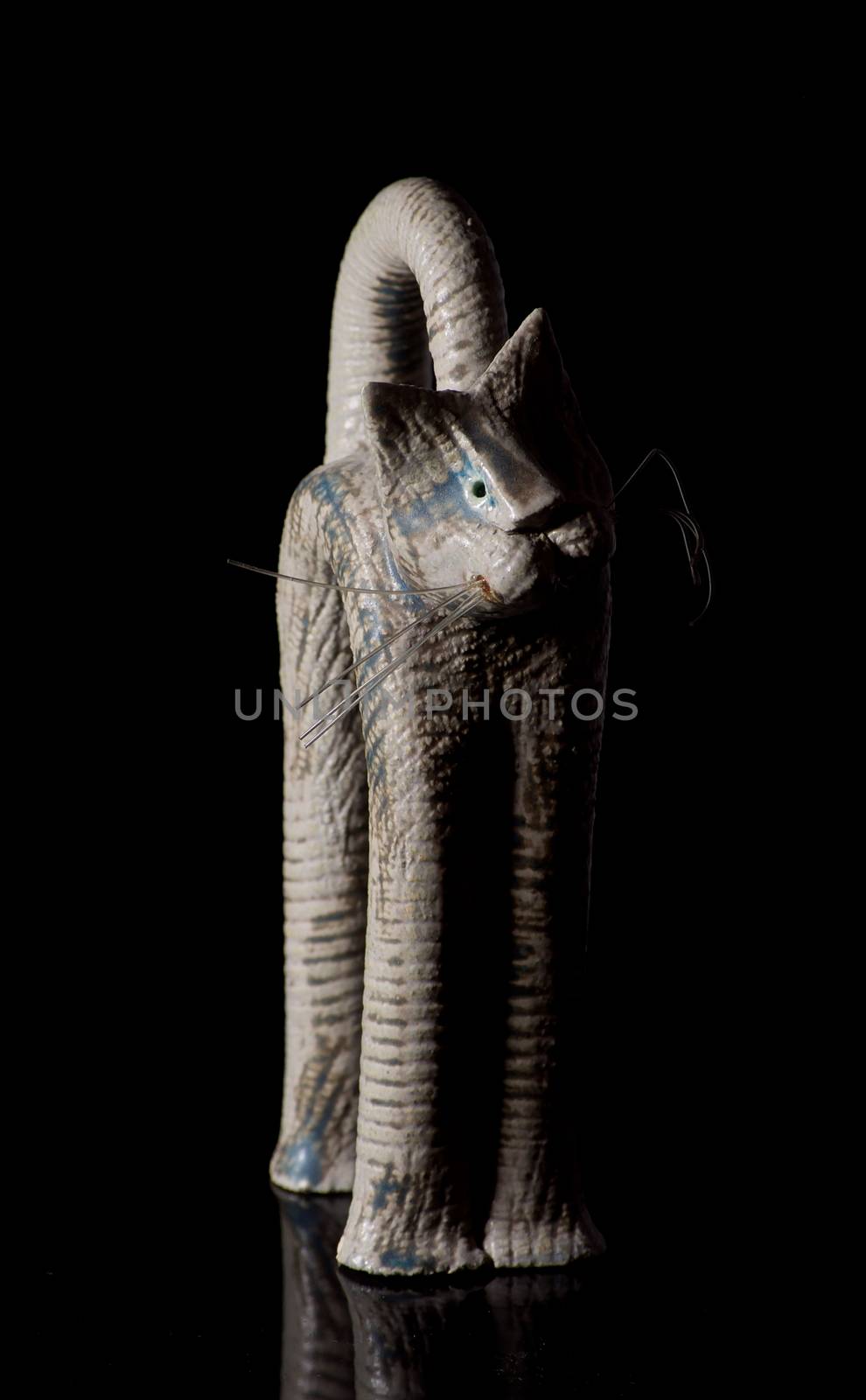 Cat figurine on black background