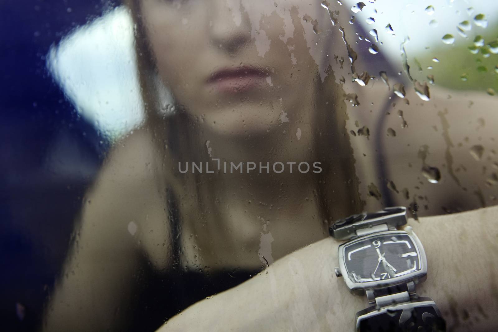 girl in the interior of a car showing a clock with storm outside