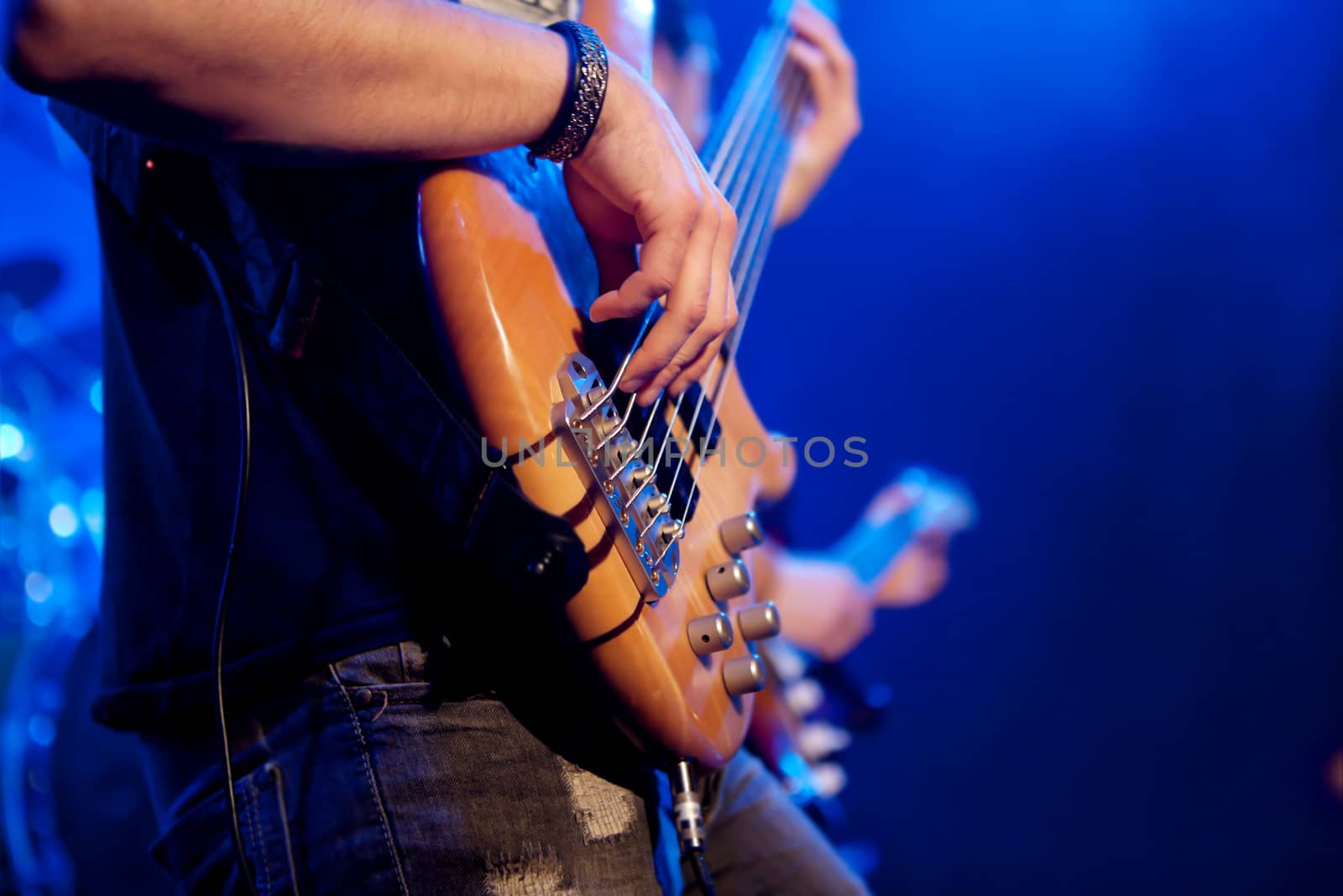 Boy hands touching the strings of a bass. live concert