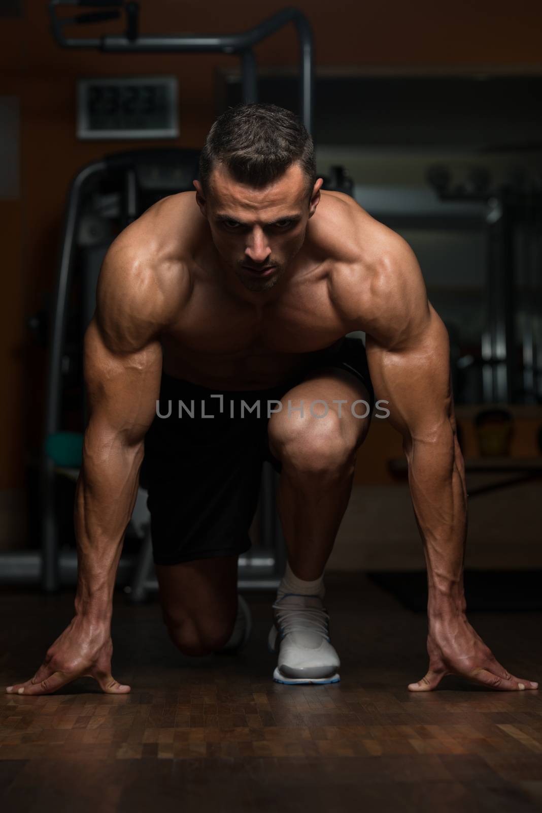 Strong Muscular Men Kneeling On The Floor by JalePhoto