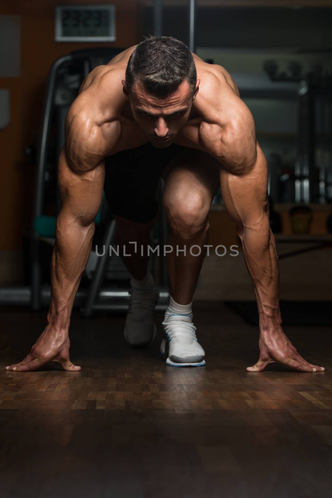 Strong Muscular Men Kneeling On The Floor - Almost Like Sprinter Starting Position