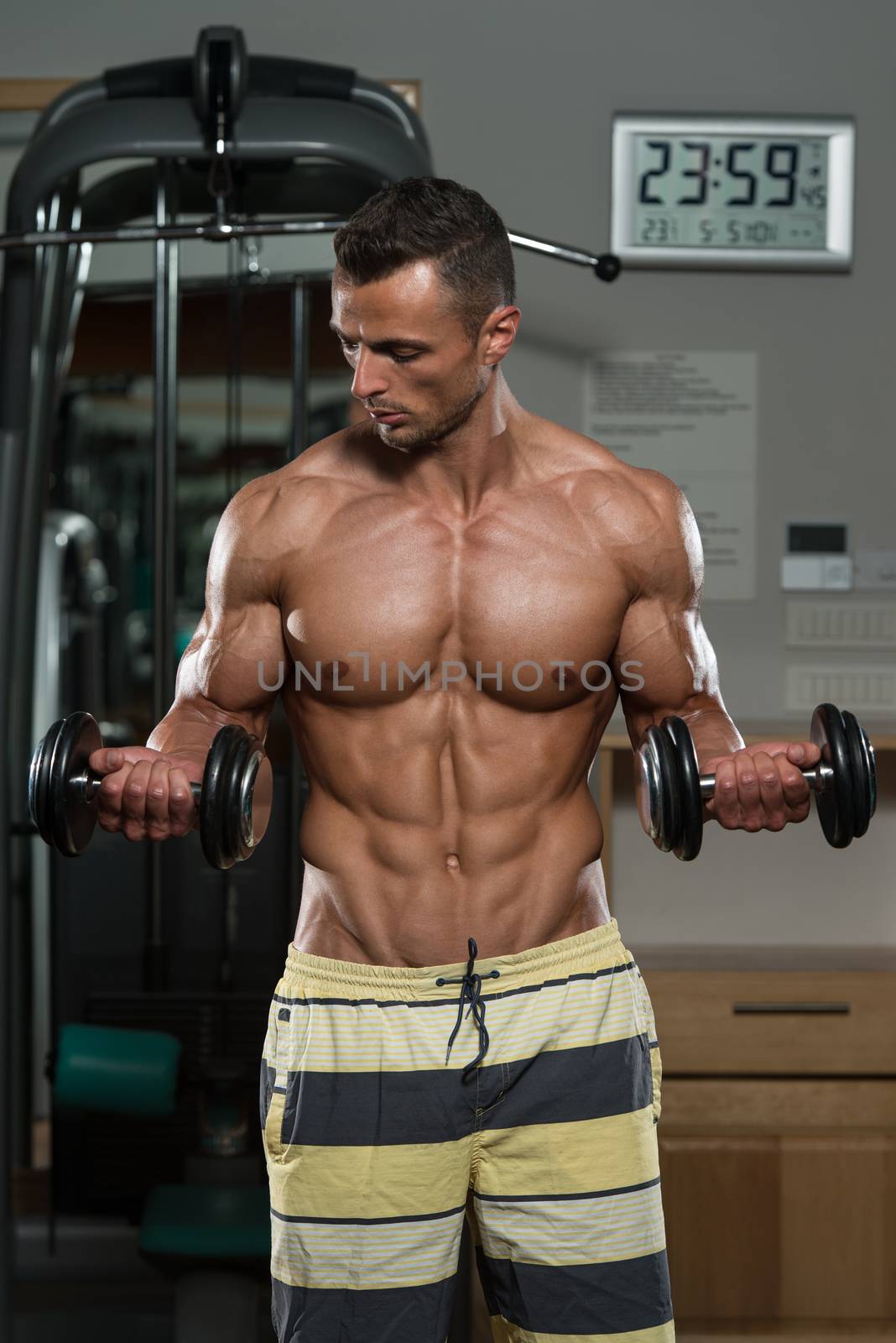 Young Man Doing Exercise For Biceps by JalePhoto