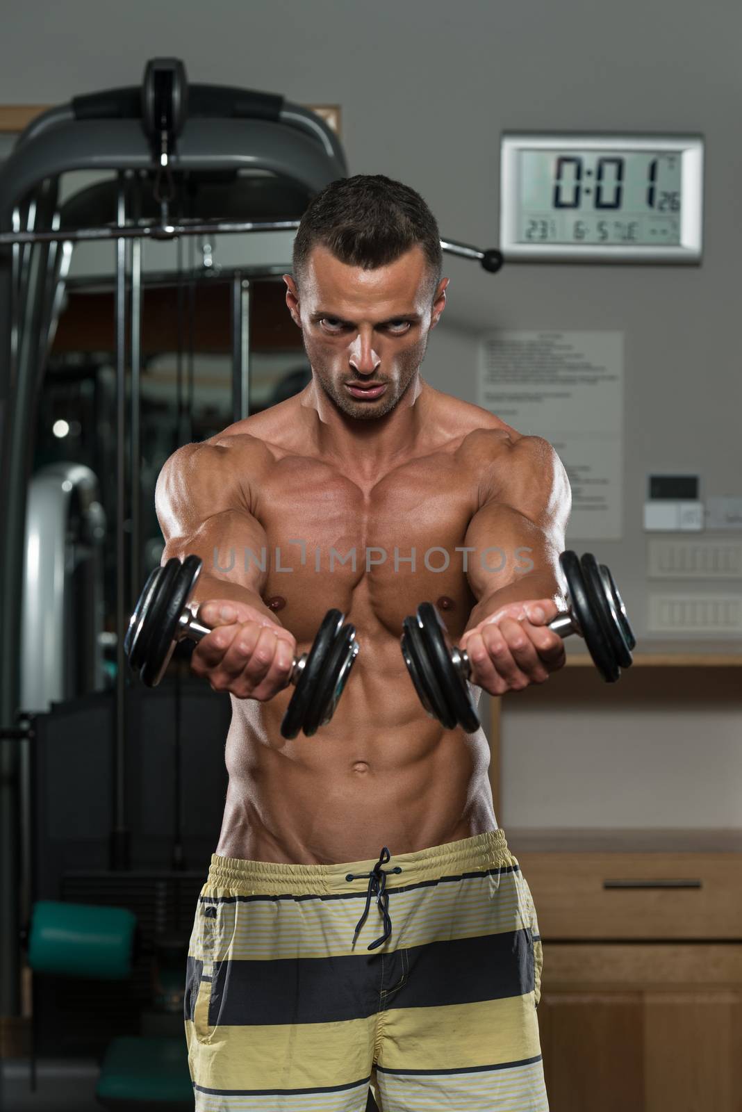 Bodybuilder Exercising Chest With Dumbbells by JalePhoto