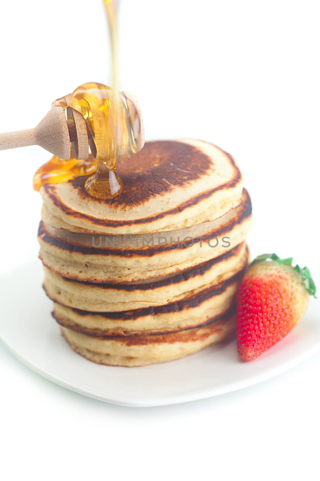 Pancakes, honey, strawberry and stick to honey isolated on white by jannyjus