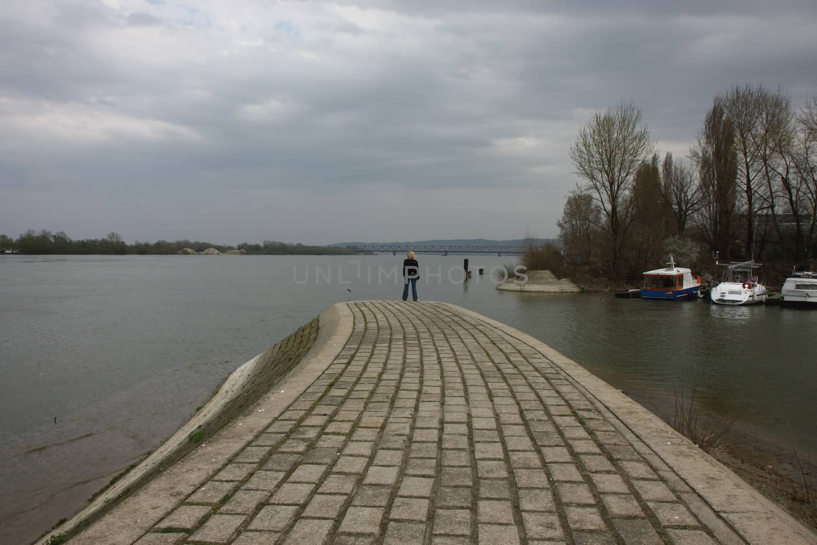 Lady standing on the end of river quay