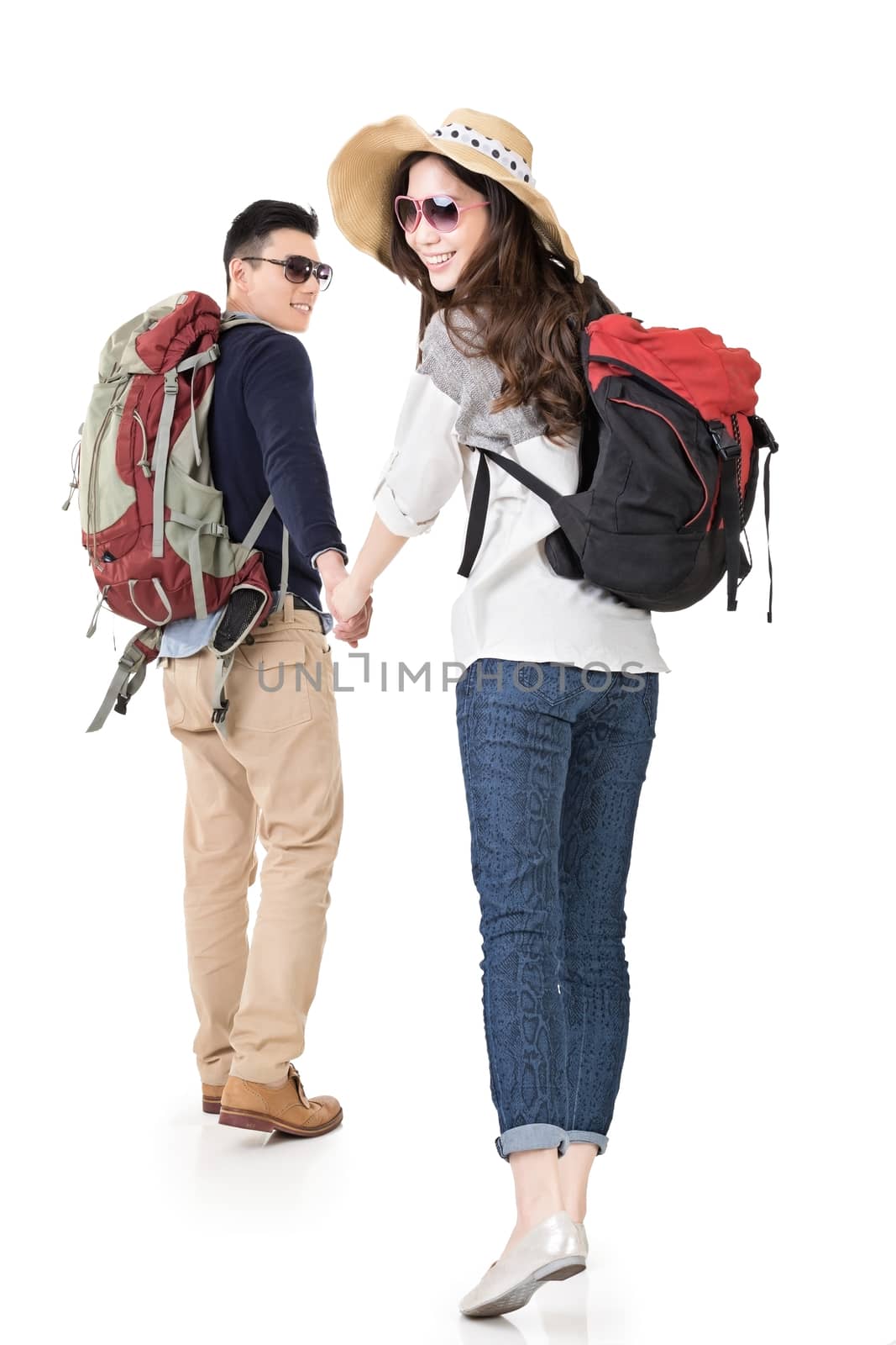 Asian young traveling couple, man holding woman's hand and lead her go to somewhere, full length portrait isolated on white background.