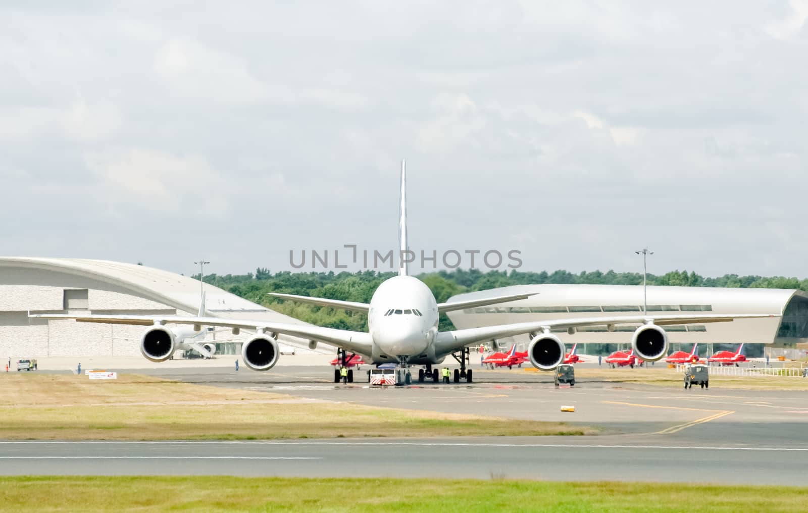 Farnborough, UK - July 25, 2010: Airbus A380 in a heat haze being prepared for take-off with the Red Arrows in the background at the Farnborough Airshow, UK