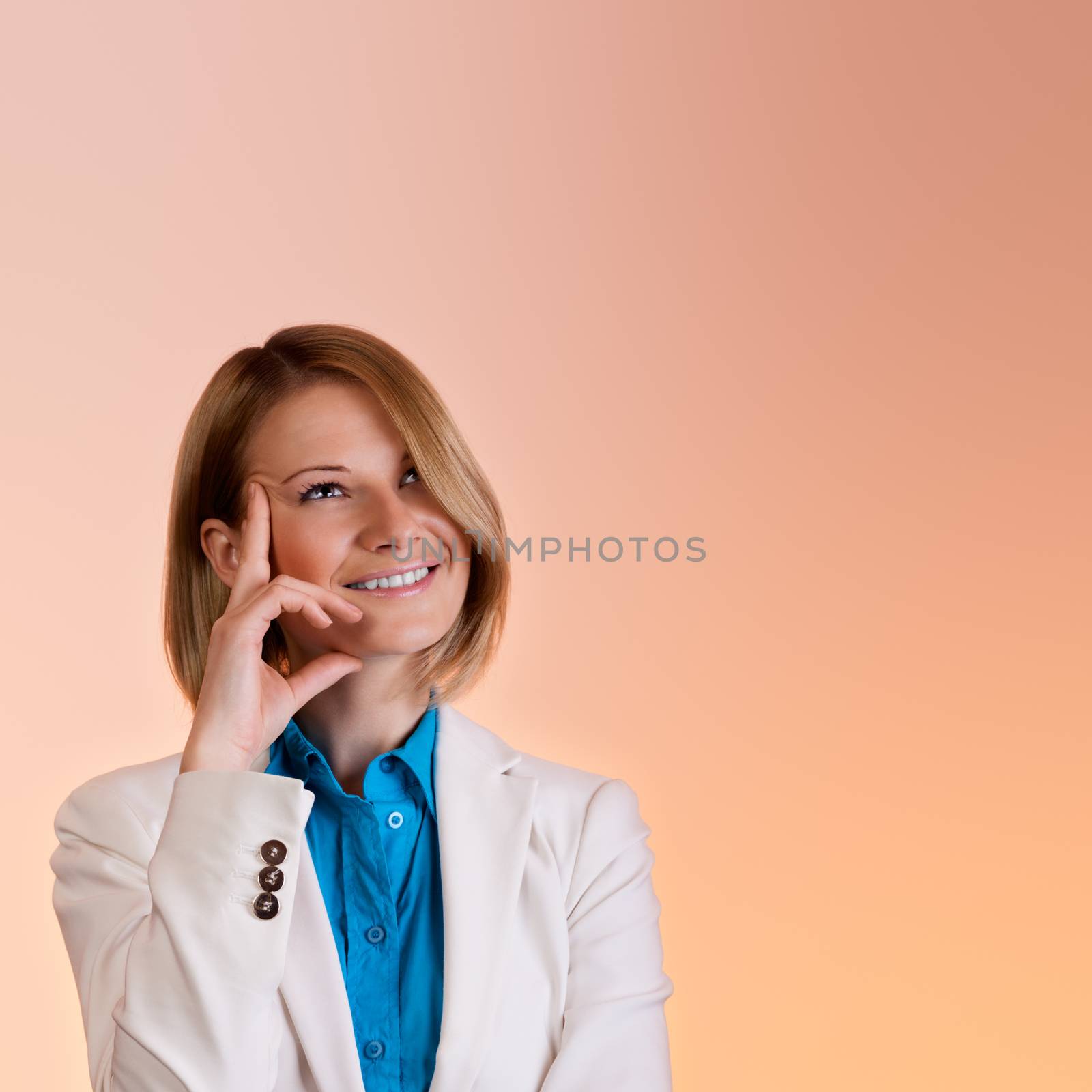 A smiling girl in a beige jacket dreamy looks up