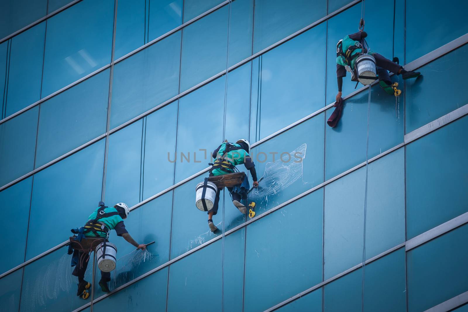 group of workers cleaning windows service on high rise building