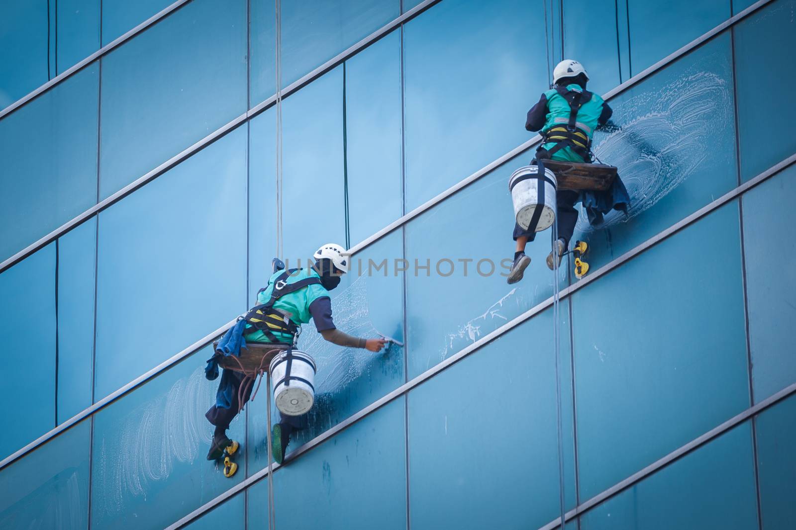 group of workers cleaning windows service on high rise building