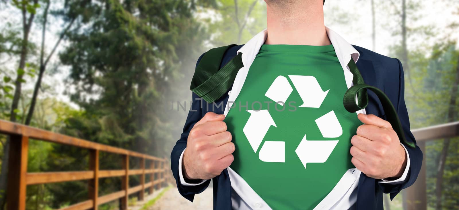 Businessman opening shirt in superhero style against bridge leading to forest