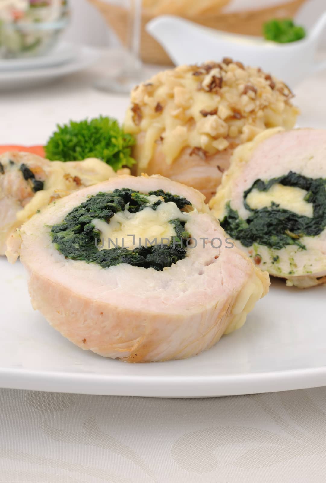 Sliced chicken roll stuffed with spinach and mozzarella and cheese with walnuts