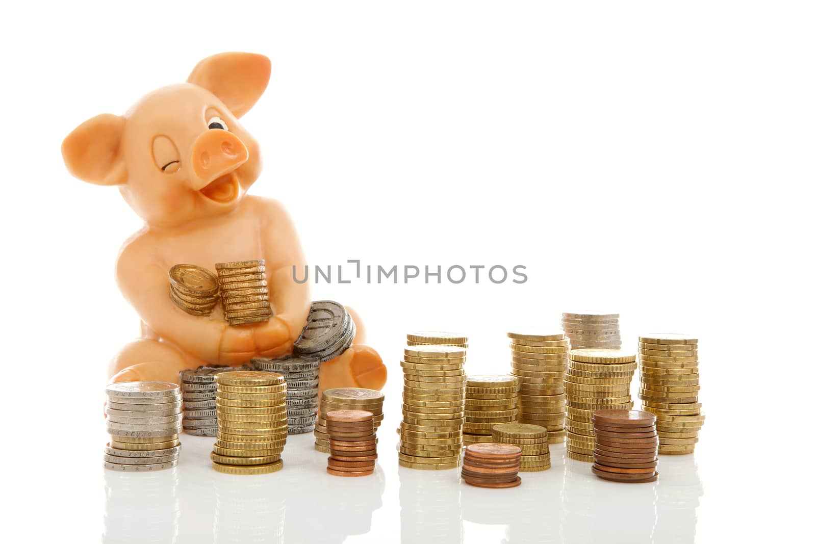 Funny piggy bank and piles of coins over white background