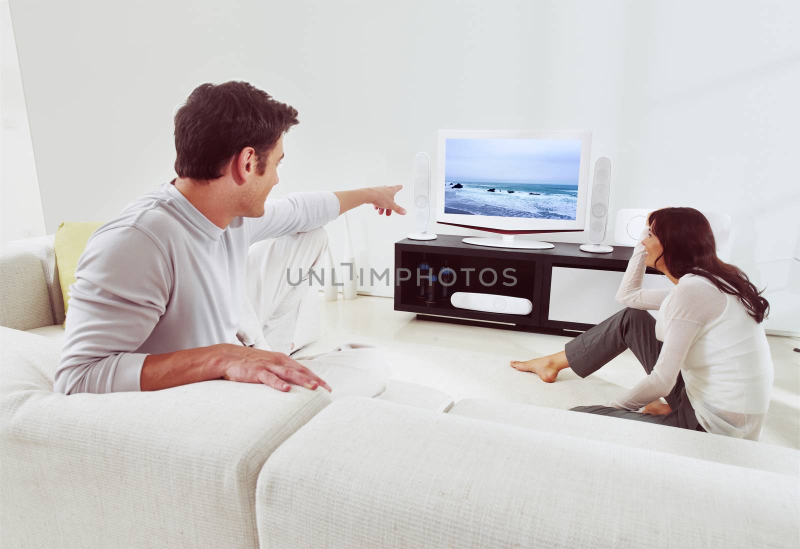 happy couple sitting on sofa and watching television together 