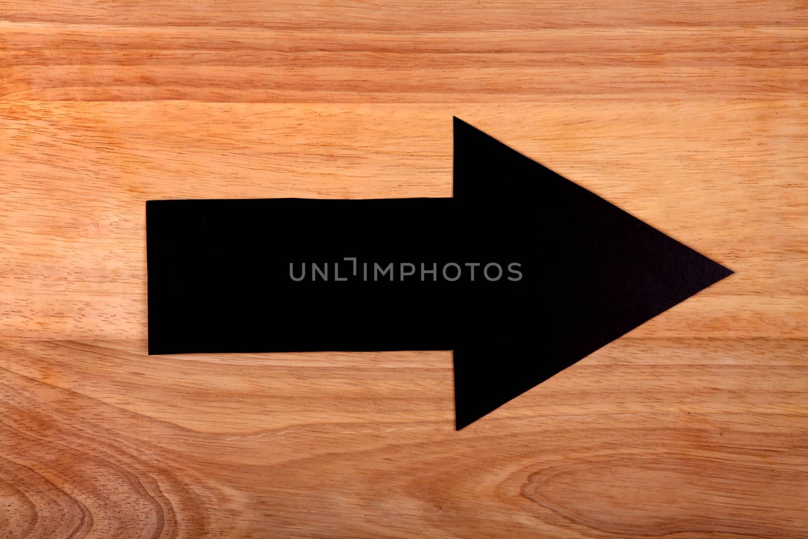 Black Arrow on the Wooden Background