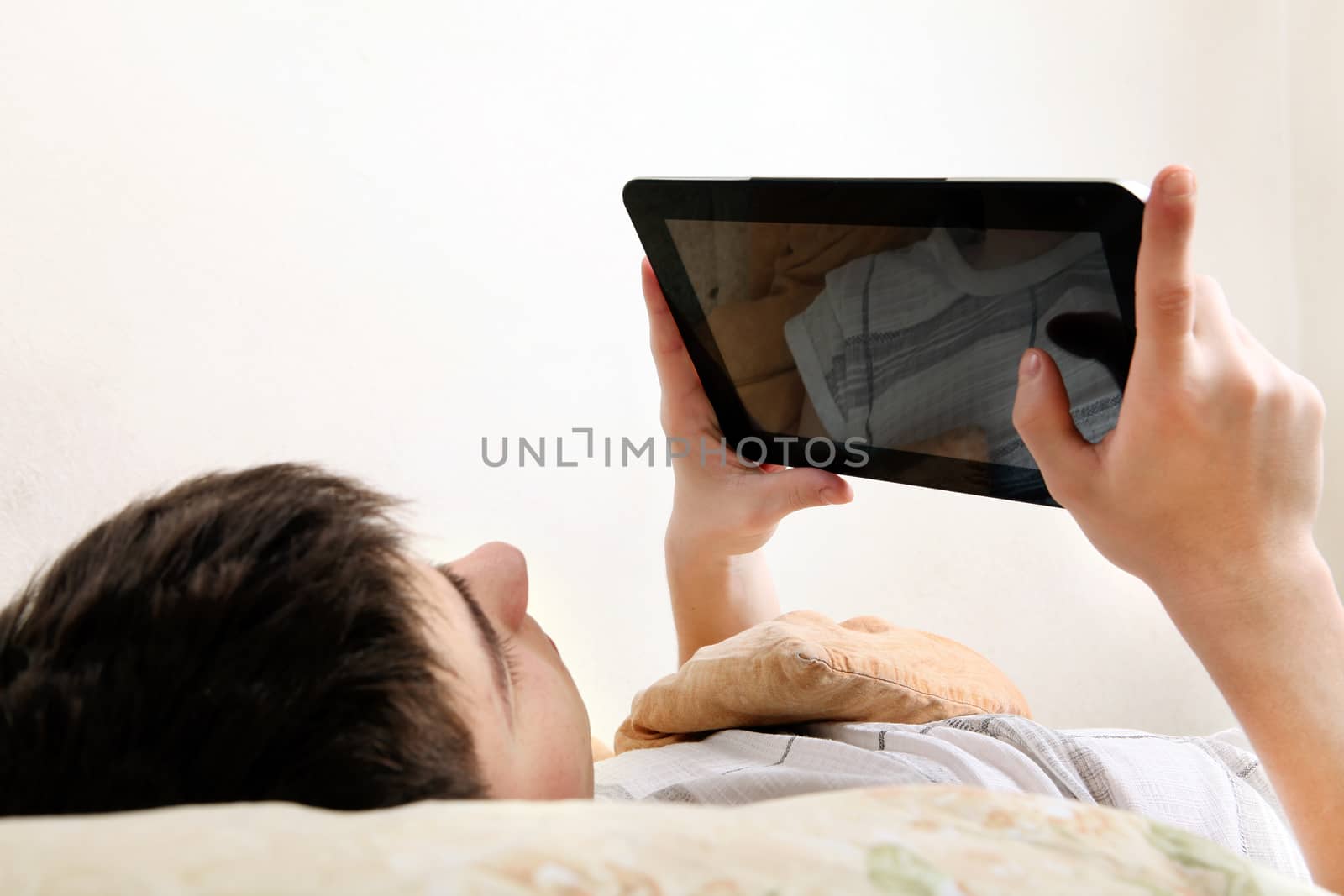 Young Man with Tablet Computer on the bed