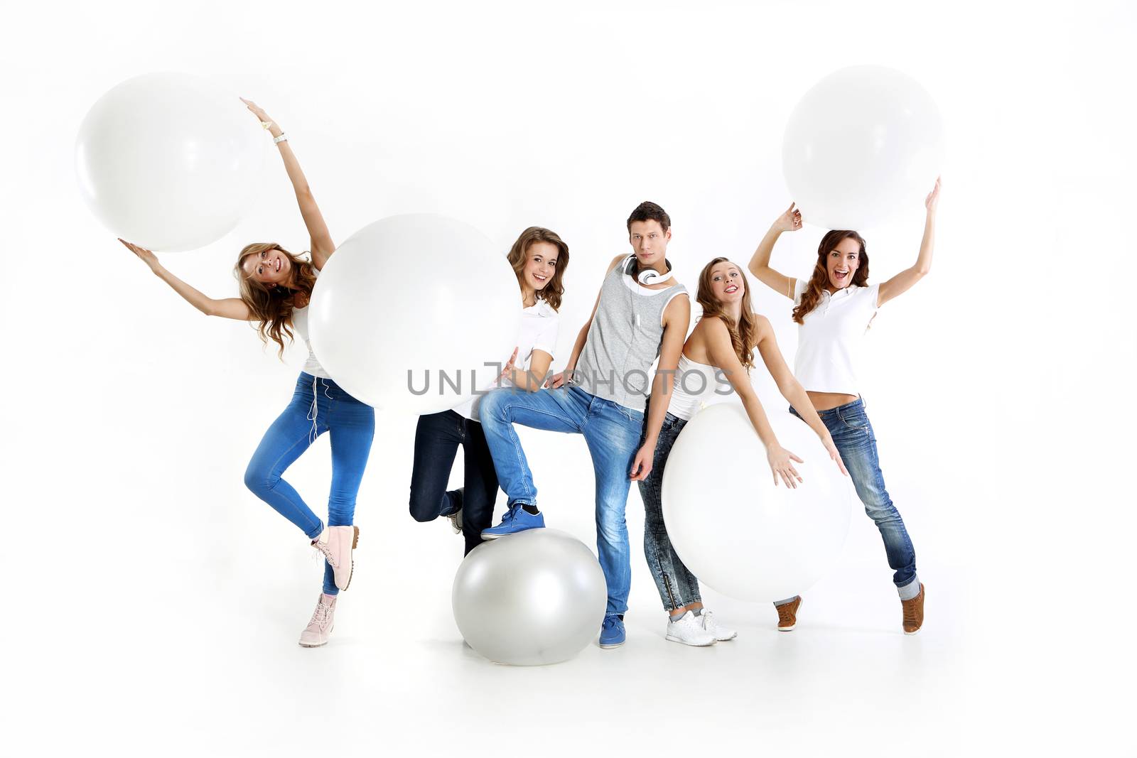 The team of five young people dressed in white shirt and jeans posing with giant balloons