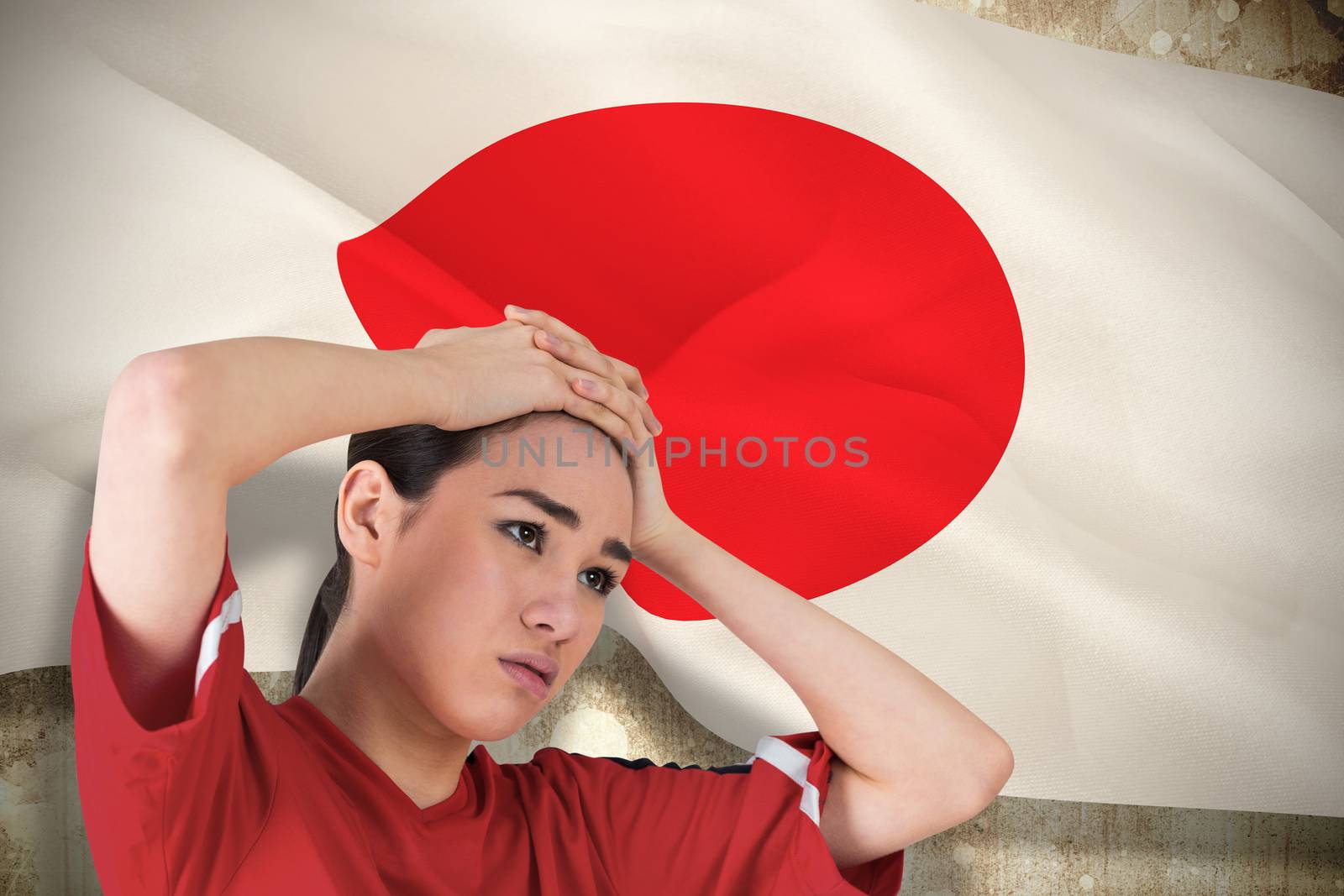 Composite image of disappointed football fan looking down against japan flag