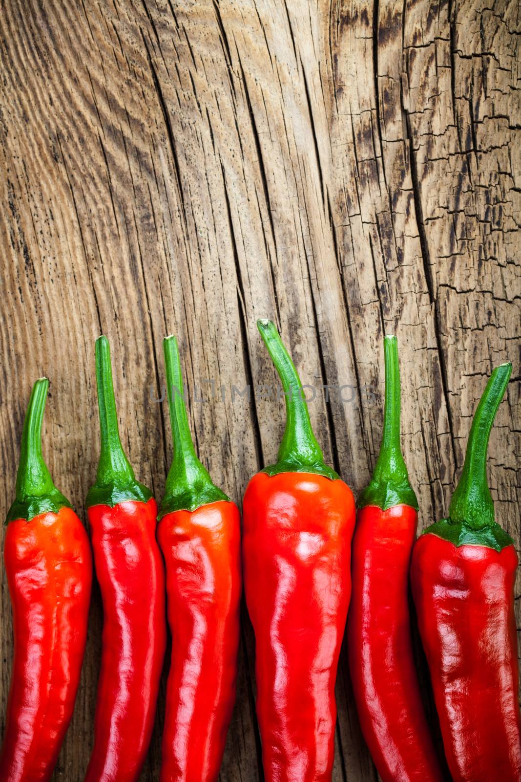 Red chilli pepper on wooden table background. Copy space. Top view