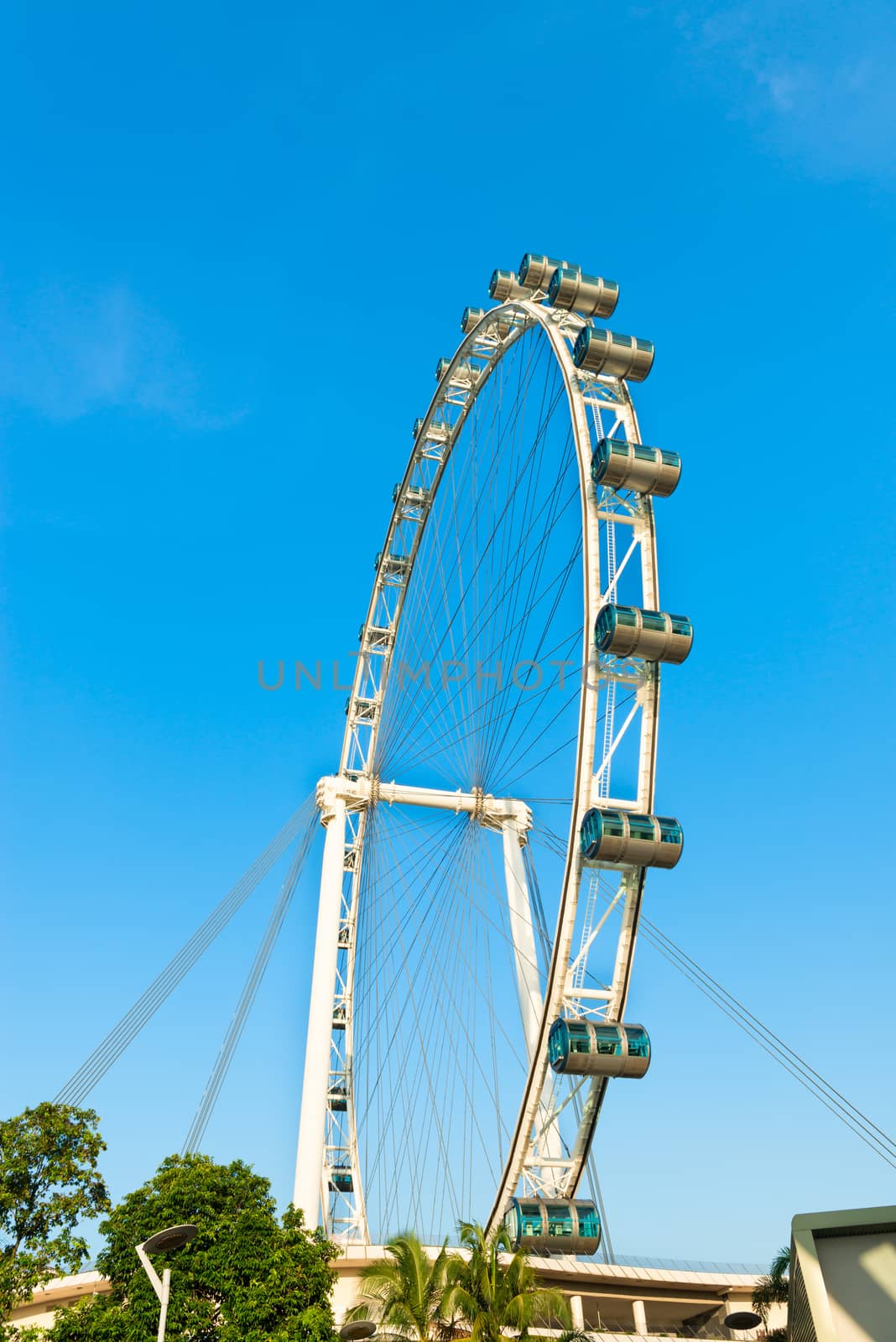 Big ferris wheel with cabins on blue sky