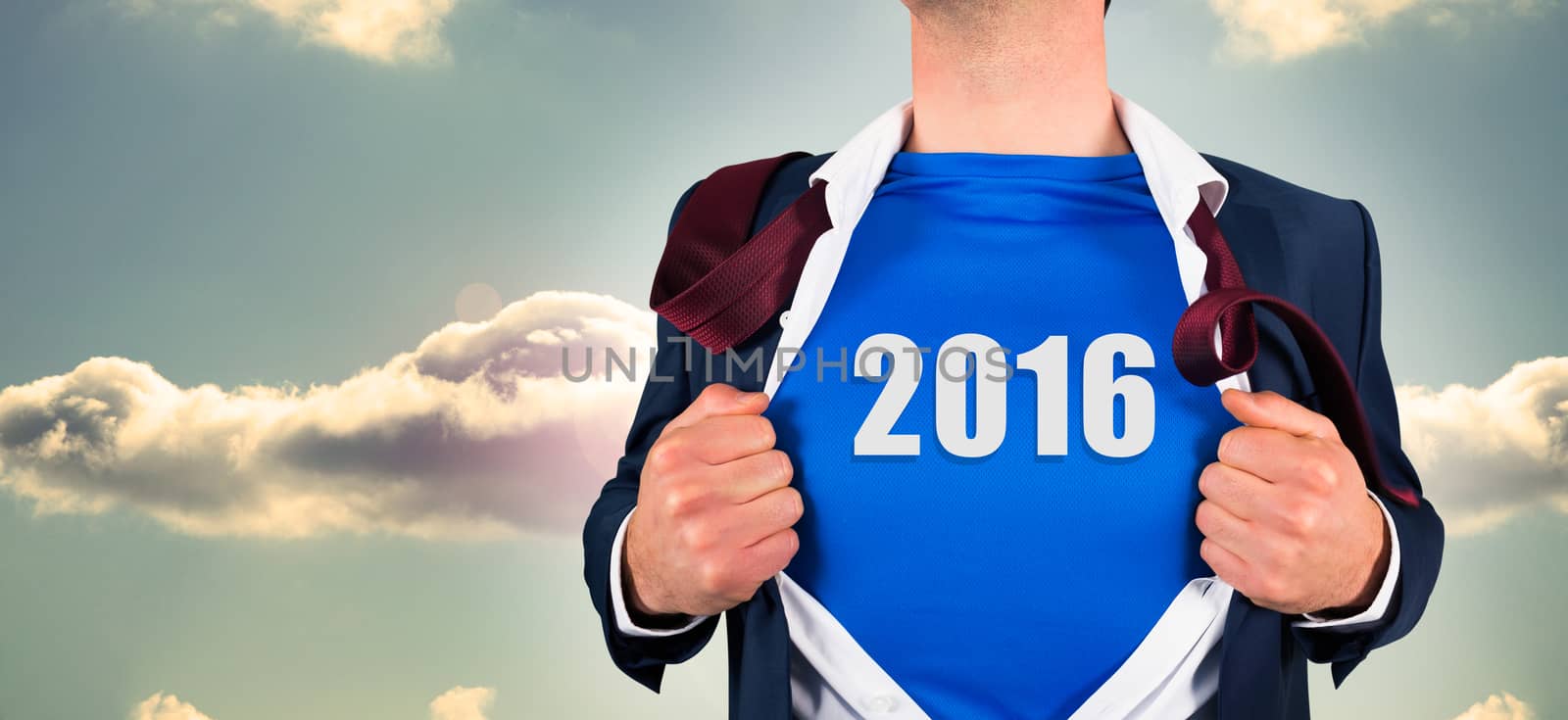 Businessman opening his shirt superhero style against bright blue sky with cloud