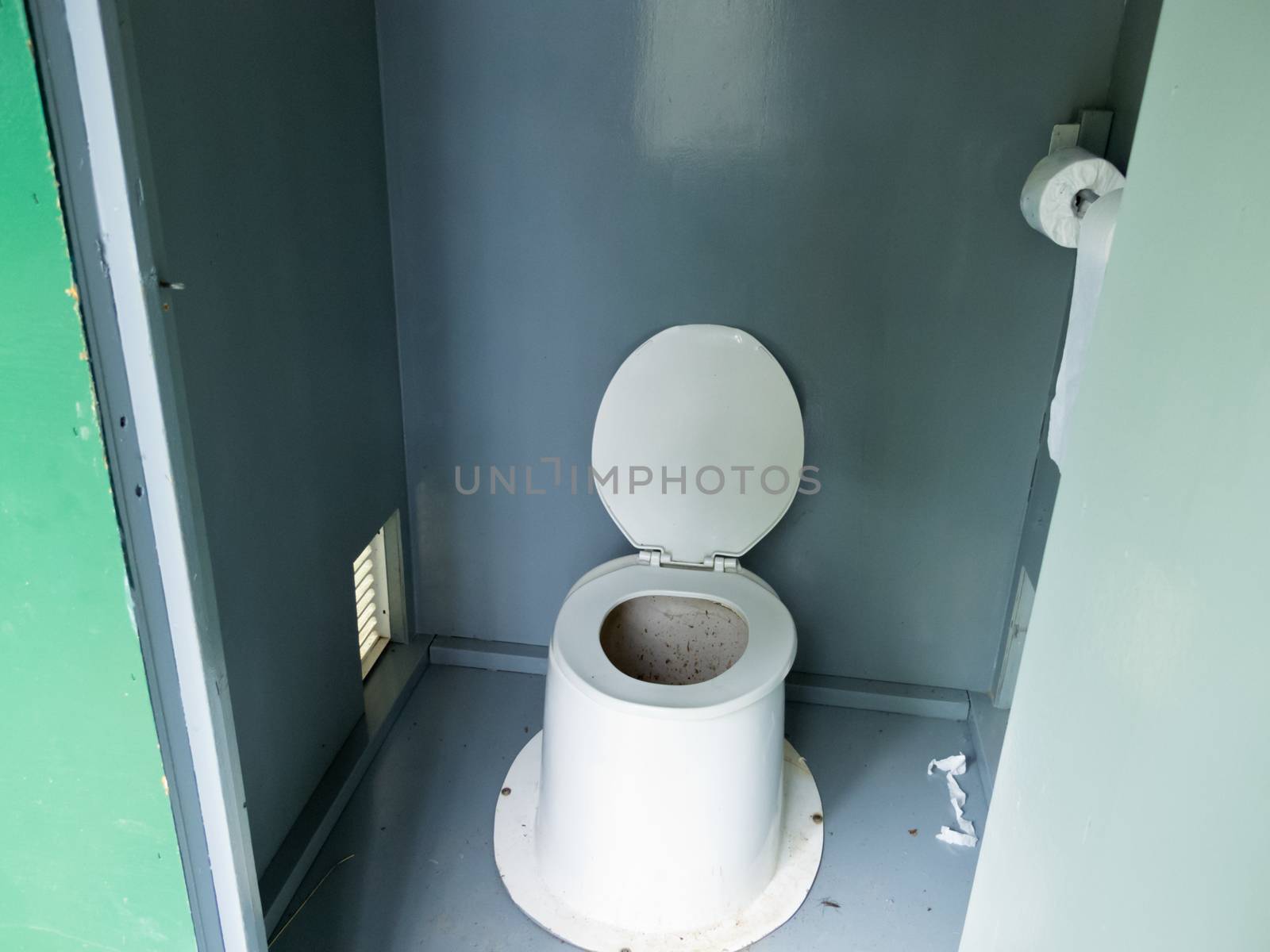 Campground pit toilet outhouse inside white plastic toilet and dirty interior to the toilet bowl with open lid
