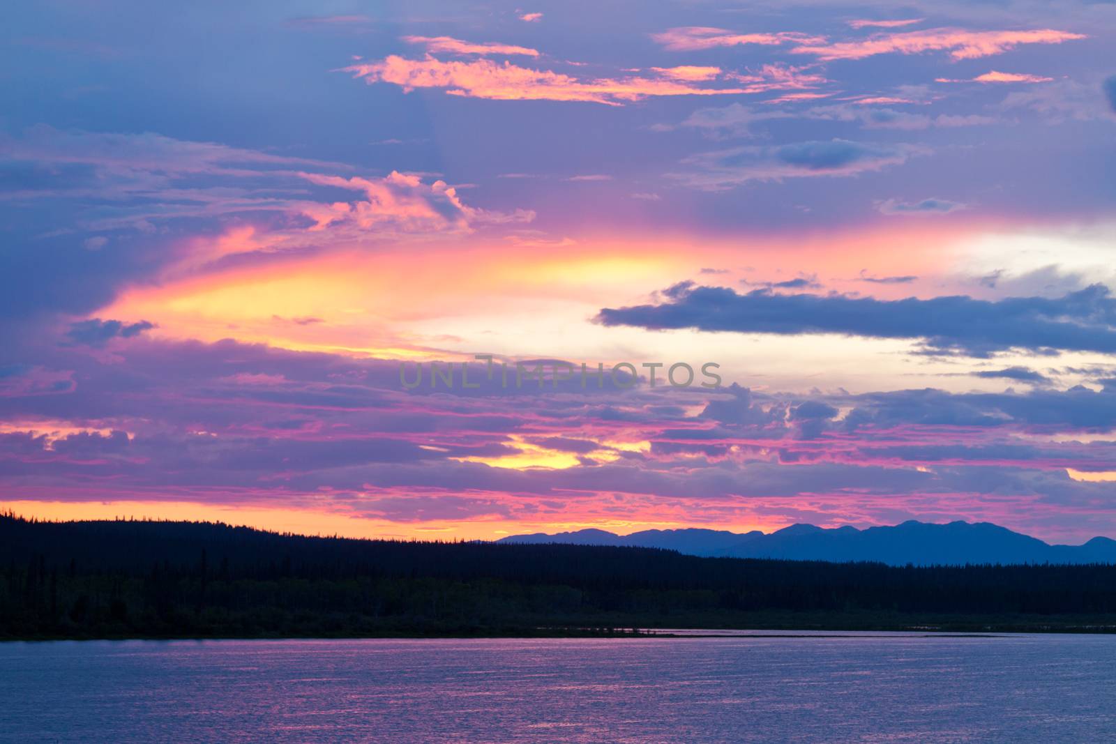 Cloudy summer sunset sky over boreal forest taiga at Six Mile River in Southern Yukon Territory, Canada